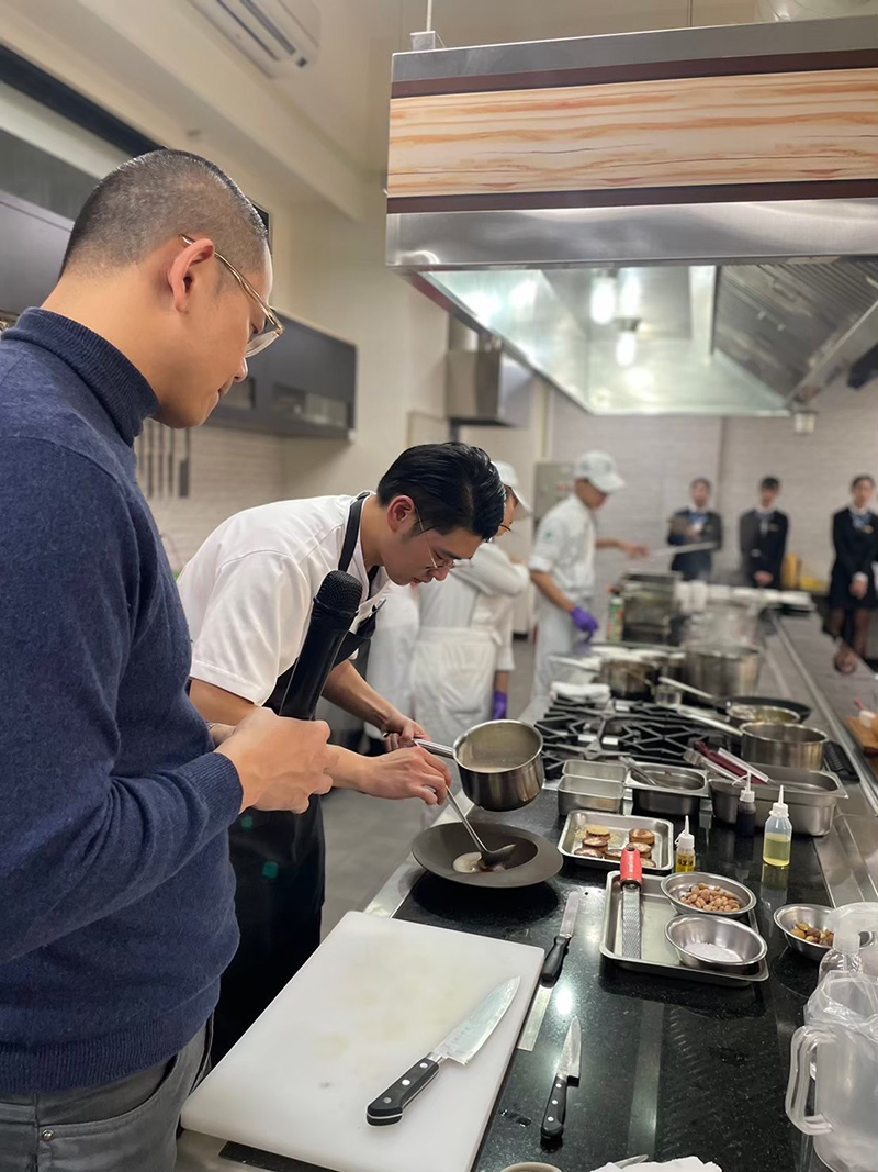 崑大餐飲系施頤(右)協助主廚江振誠進行廚藝示範課程（圖／崑山科技大學提供）