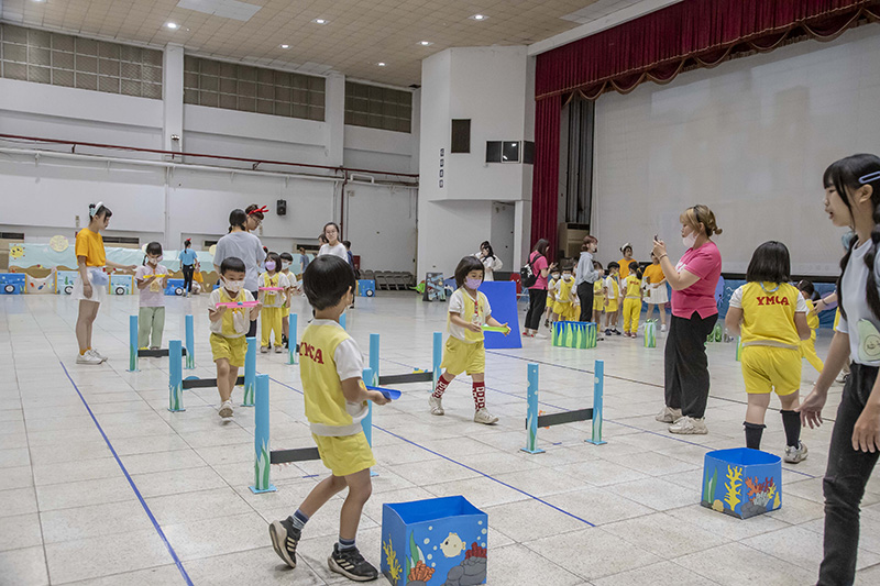 小朋友用管子裝魚踏過障礙物送「小魚回家」。(圖/嘉南藥理大學提供)