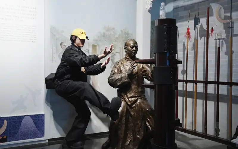 台灣青年走進廣州市新文化館，體驗嶺南武術文化，在詠春木人樁展示區與雕像互動，感受在地傳統文化魅力。(記者楊婉攝)