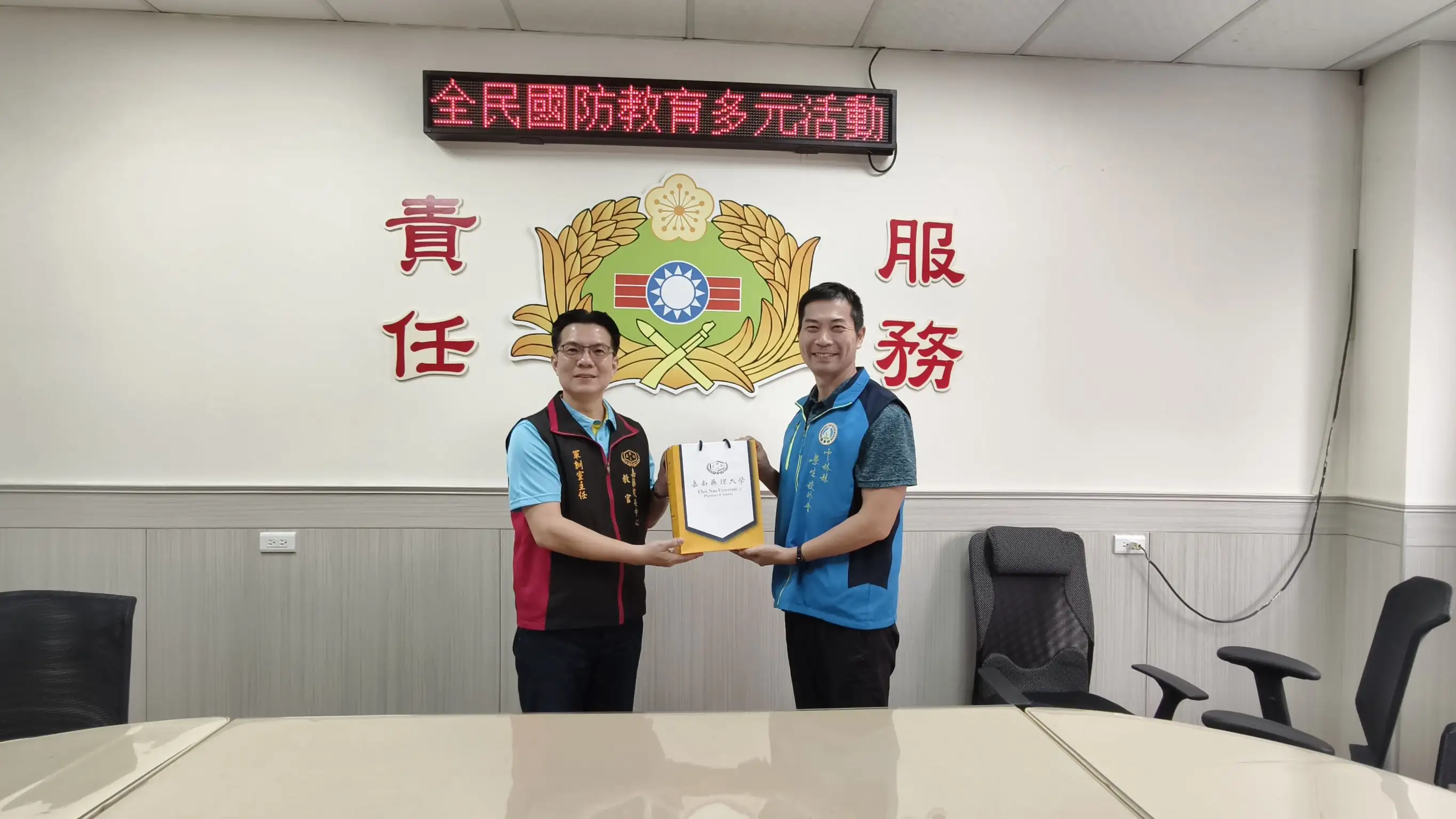 嘉藥師生與教育部雲林聯絡處交流推動全民國防教育經驗，由李柏宏主任(左)代表致贈禮品。(圖/嘉南藥理大學 提供)