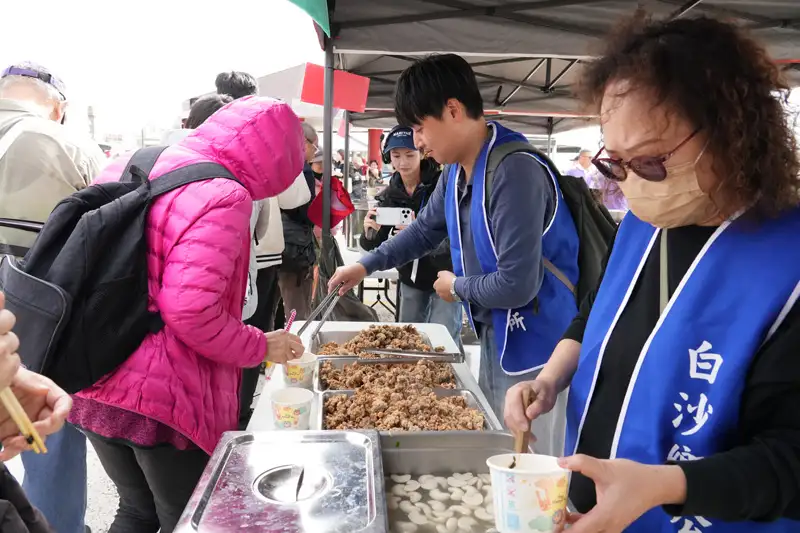 白沙鄉公所準備在地海味料理供民眾享用，參與者排隊領取熱食，以澎湖道地滋味為活動畫下暖心收尾。(圖/澎湖縣政府提供)