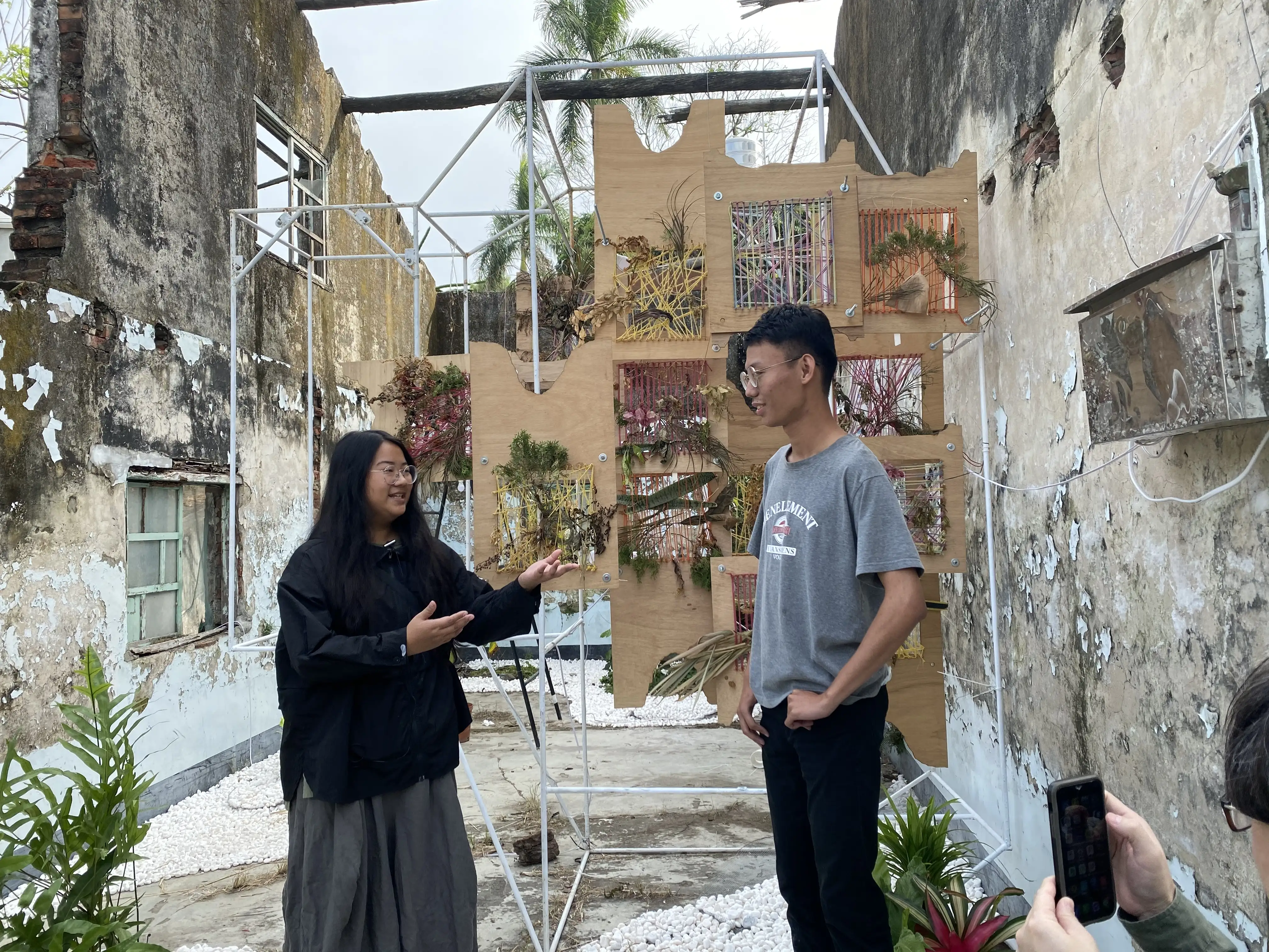 參與作品的研究生林佳妤(左)和黃傳懿(右)於《地空膠囊》裝置前討論創作細節。(圖/ 崑山科技大學 提供)