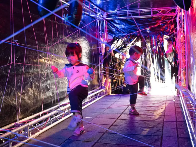 小朋友在「盤絲洞」主題關卡中穿梭挑戰，體驗沉浸式冒險遊戲的樂趣。(圖/德妮幼教機構提供)