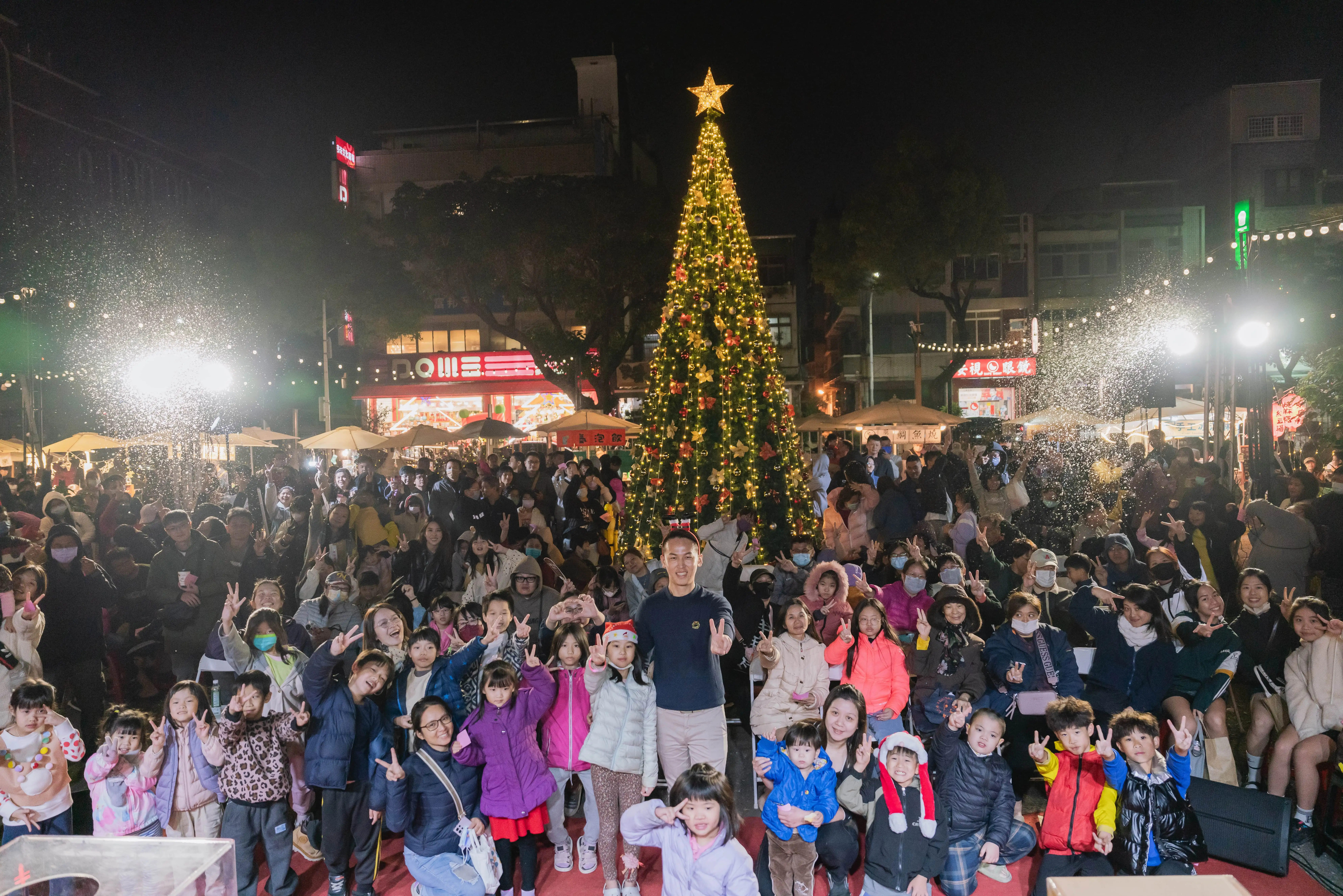 下午5時30分，8米高聖誕樹點燈，夢幻飄雪每30分鐘緩緩飄落，張騏晟與民眾共度溫馨週末之夜。（記者吳文生攝）