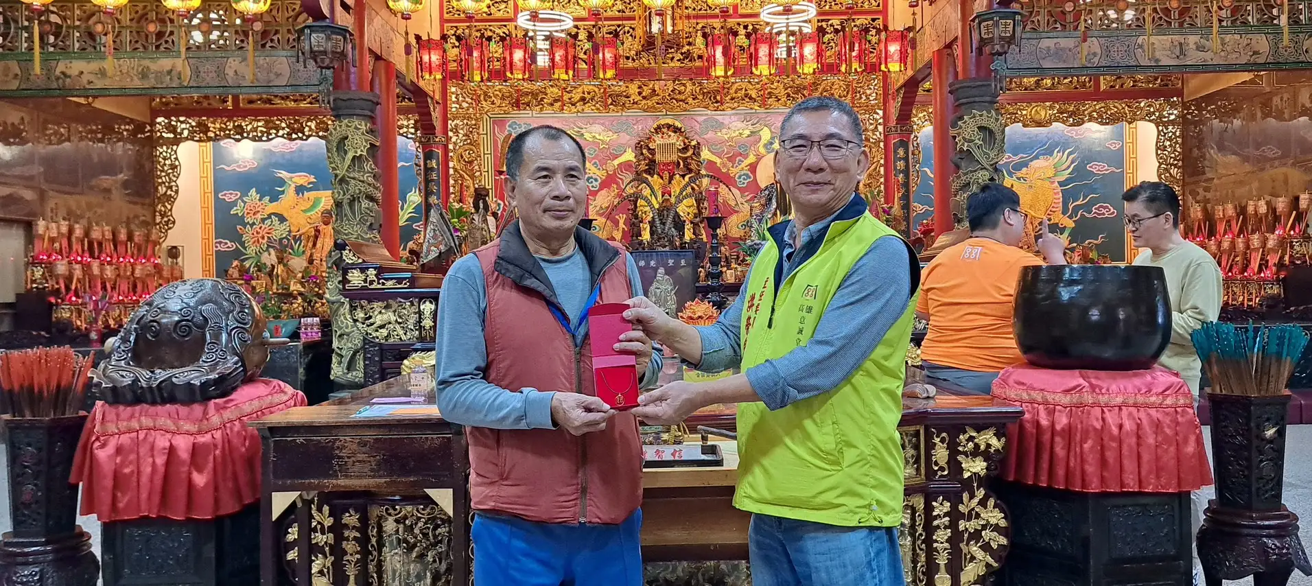 洪榮豊主委頒贈關帝聖君獎金墜子一枚給博得最多聖杯的大專社會組首獎選手黃文彬。（意誠堂提供）