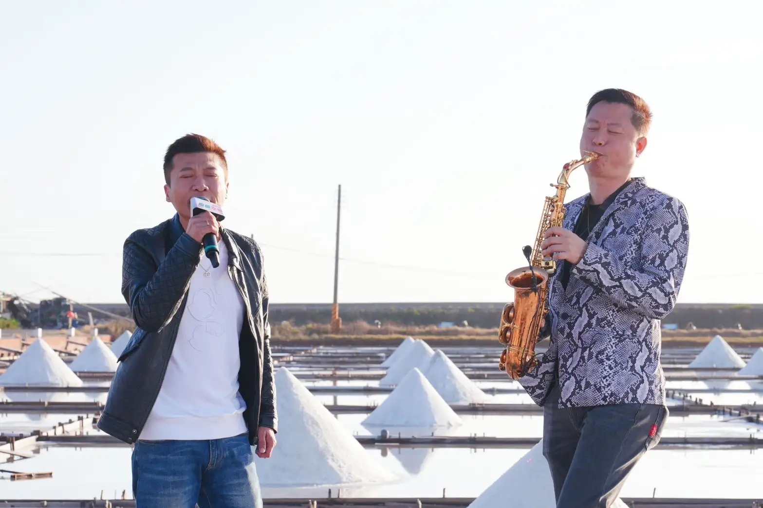 歌手方順吉（左）深情獻唱，搭配薩克斯風演奏家黃文龍老師（右）精彩的演出，在瓦盤鹽田夕照映襯下，為鹽續幸福音樂會揭開序幕。(圖/雲嘉南濱海國家風景區管理處提供)