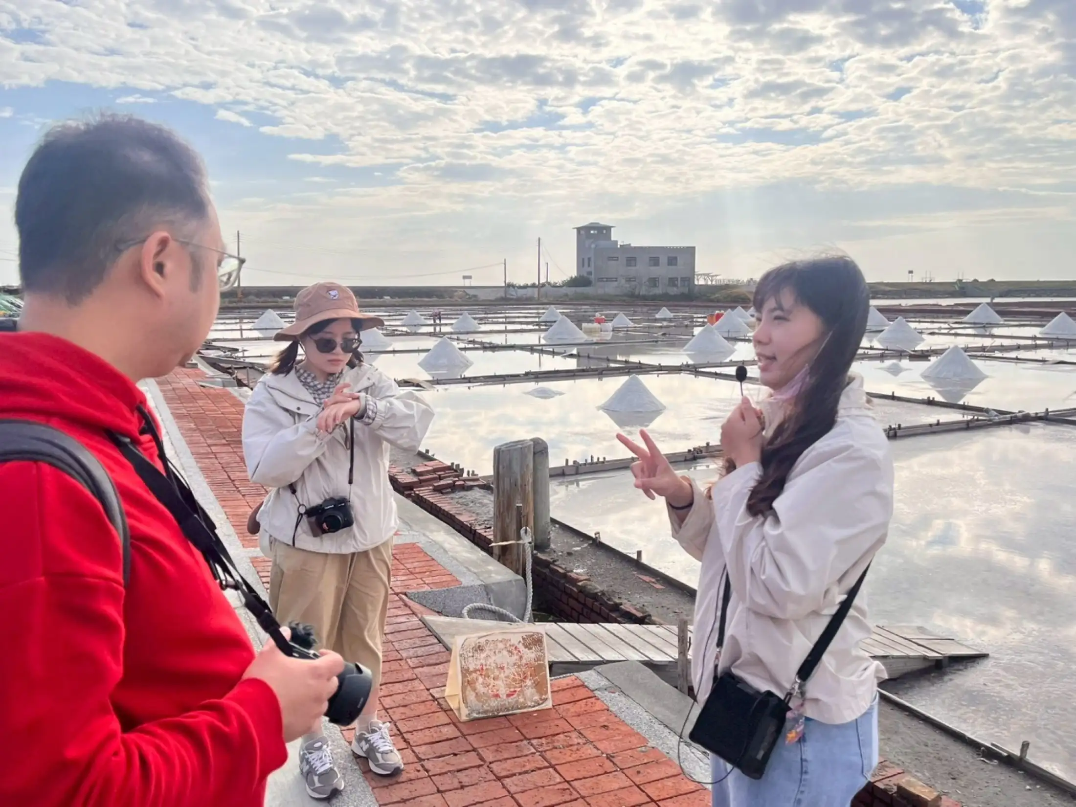 導覽人員向馬來西亞媒體團解說傳統曬鹽工法。(圖/臺南市政府觀光旅遊局 提供)