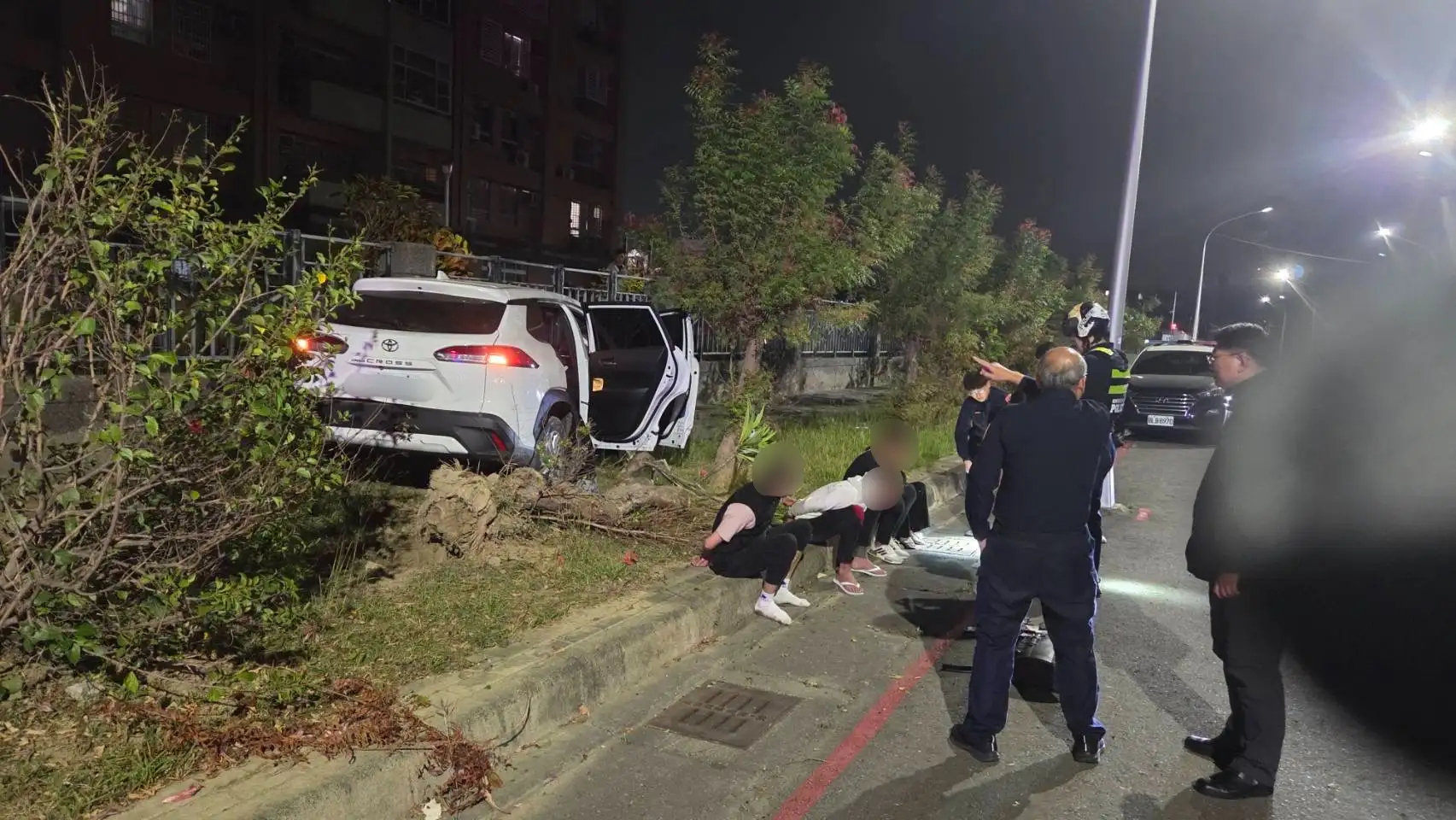 高雄左營債務糾紛引發飛車追逐，白色自小客車自撞路樹停靠路旁，警方在車內查獲刀械及毒品，所幸未造成人員傷亡。(圖/左營分局提供)