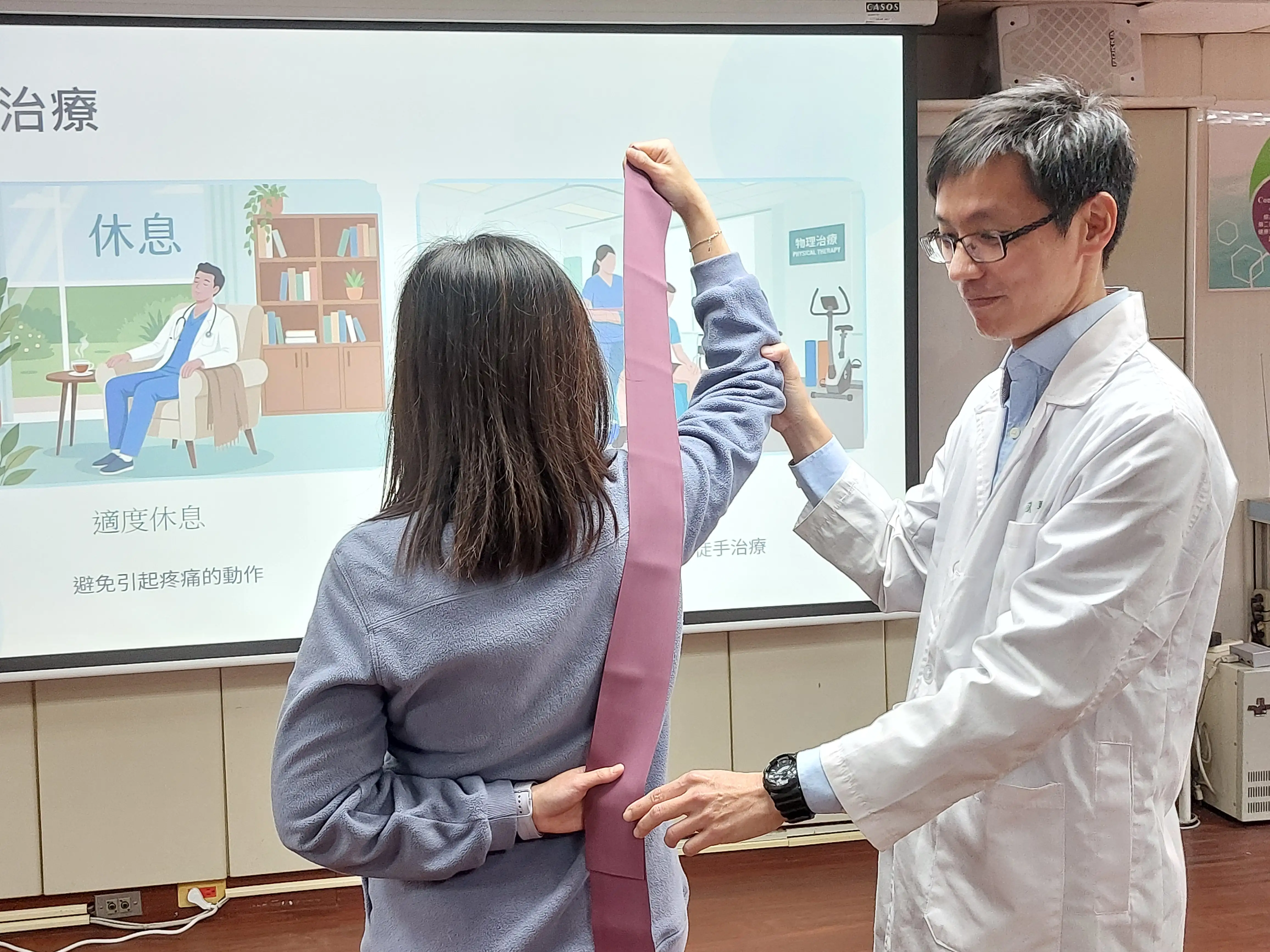 衛生福利部臺南醫院復健科主治醫師張竣凱復示範彈力帶運動，協助肩痛患者進行肌力與活動度訓練，降低復發風險。(記者林怡孜攝)