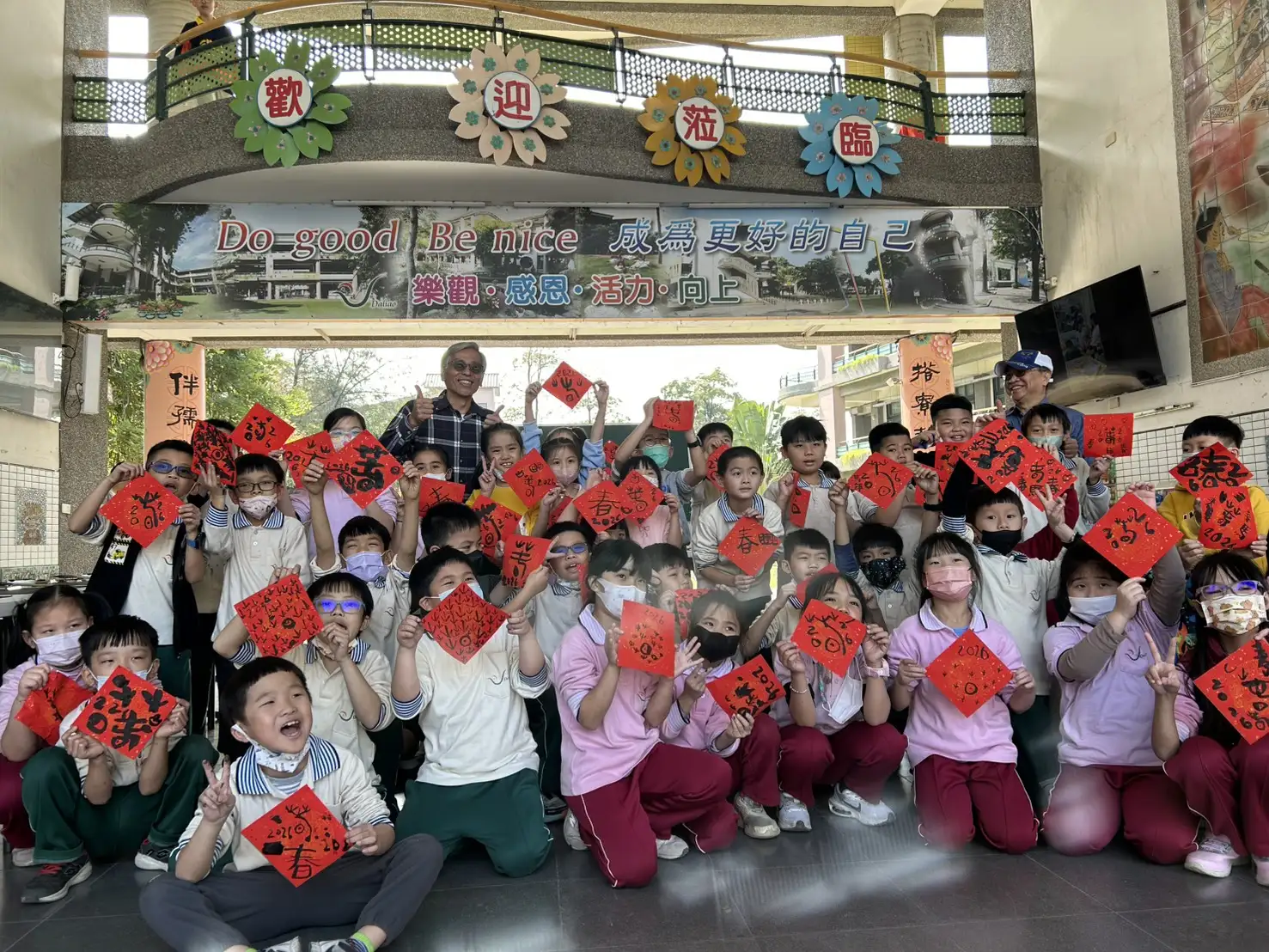 現任校長甄炳炫、退休校長陳昭治與蘭亭書學會理事長吳文生指導學生春聯揮毫，低年級寫象形與甲骨文春字，六年級畫福字。（記者吳文生攝）