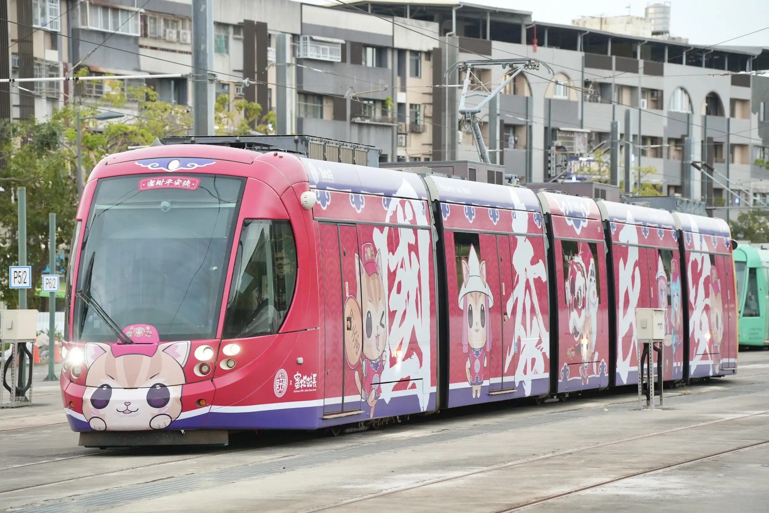 高雄輕軌「蜜柑萌虎平安號」彩繪列車行駛市區，車身滿版萌虎與蜜柑圖樣，吸引民眾目光，成為城市新亮點。(圖/高雄市政府提供)