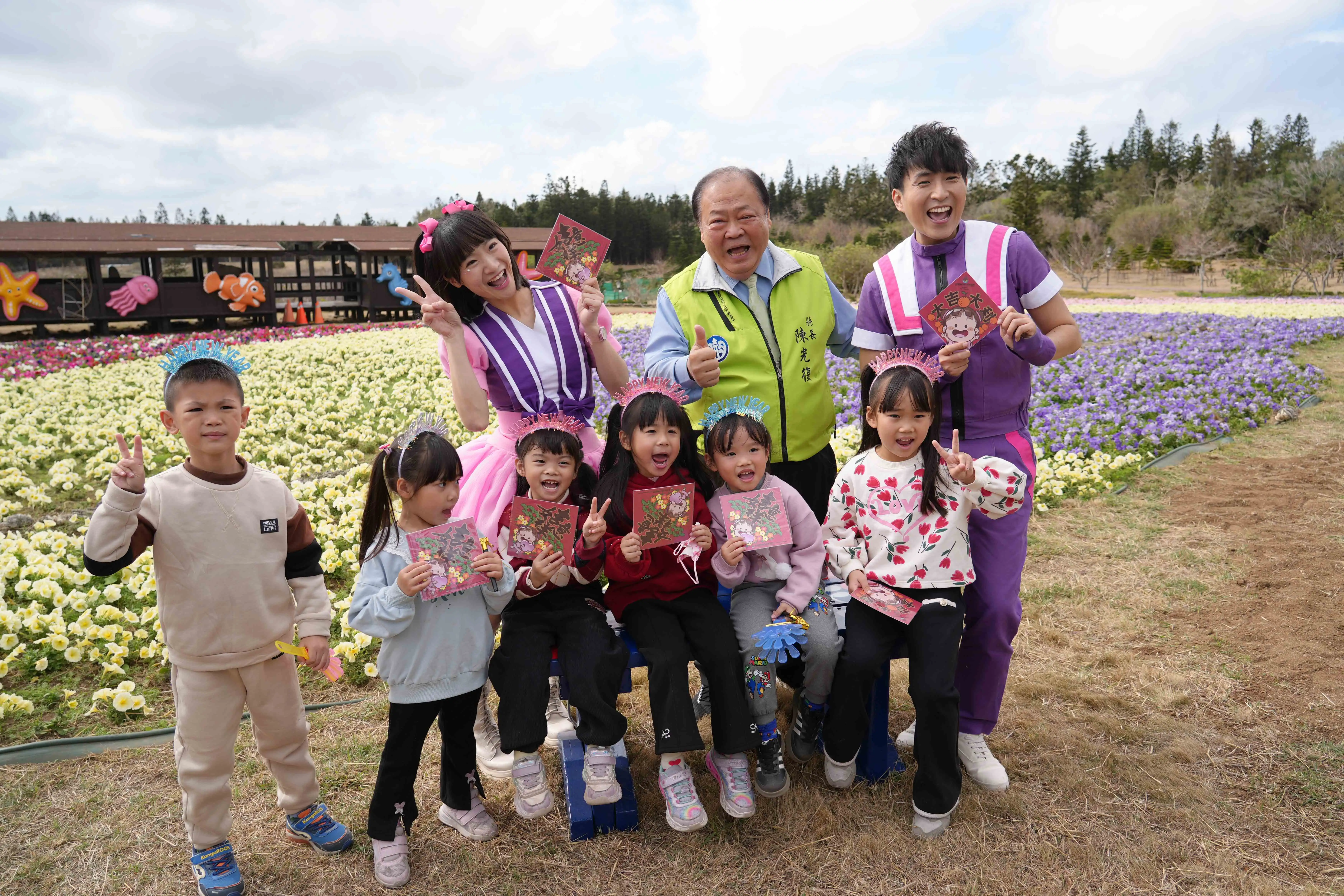 澎湖縣長陳光復與小朋友一同在繽紛花海中合影，發送新春小禮物，現場充滿歡笑與溫馨年節氣氛。(圖/澎湖縣政府提供)