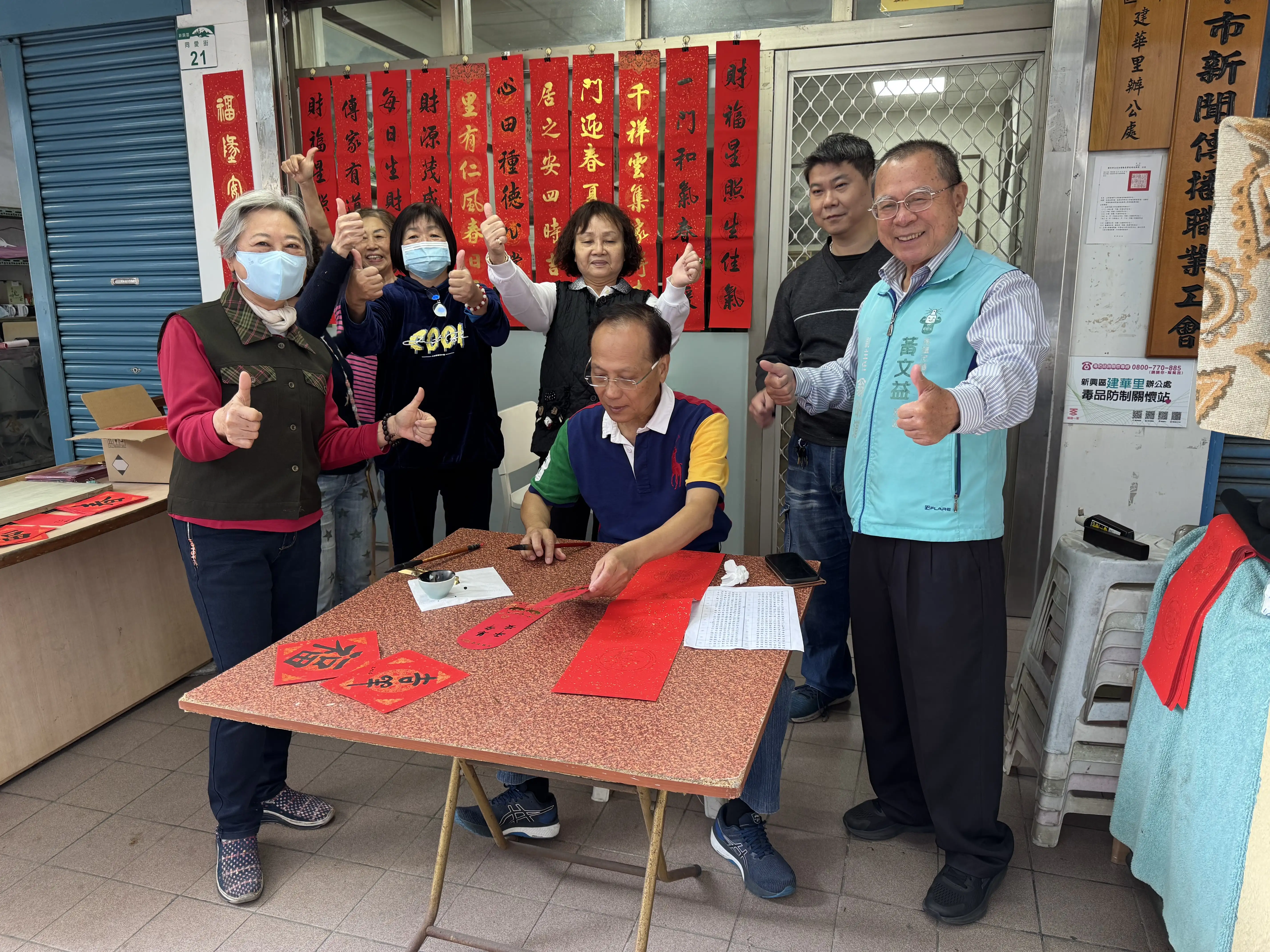 高雄市新興區建華里長服務處循例邀請書法名家吳文生現場揮毫，贈送春聯給鄉親。（記者吳文欽／攝）