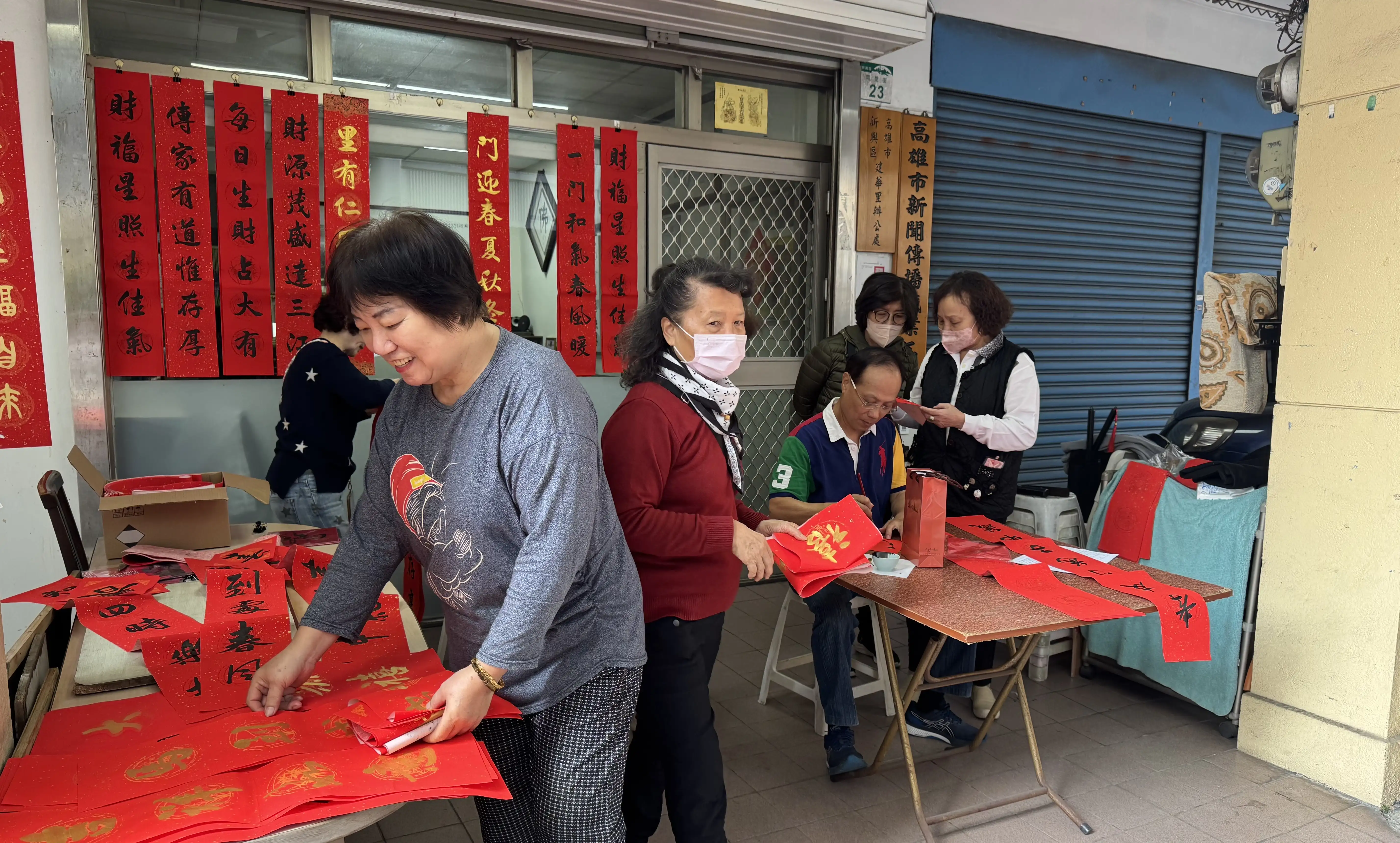 高雄市新興區建華里長服務處循例邀請書法名家吳文生現場揮毫，贈送春聯給鄉親。（記者吳文欽／攝）