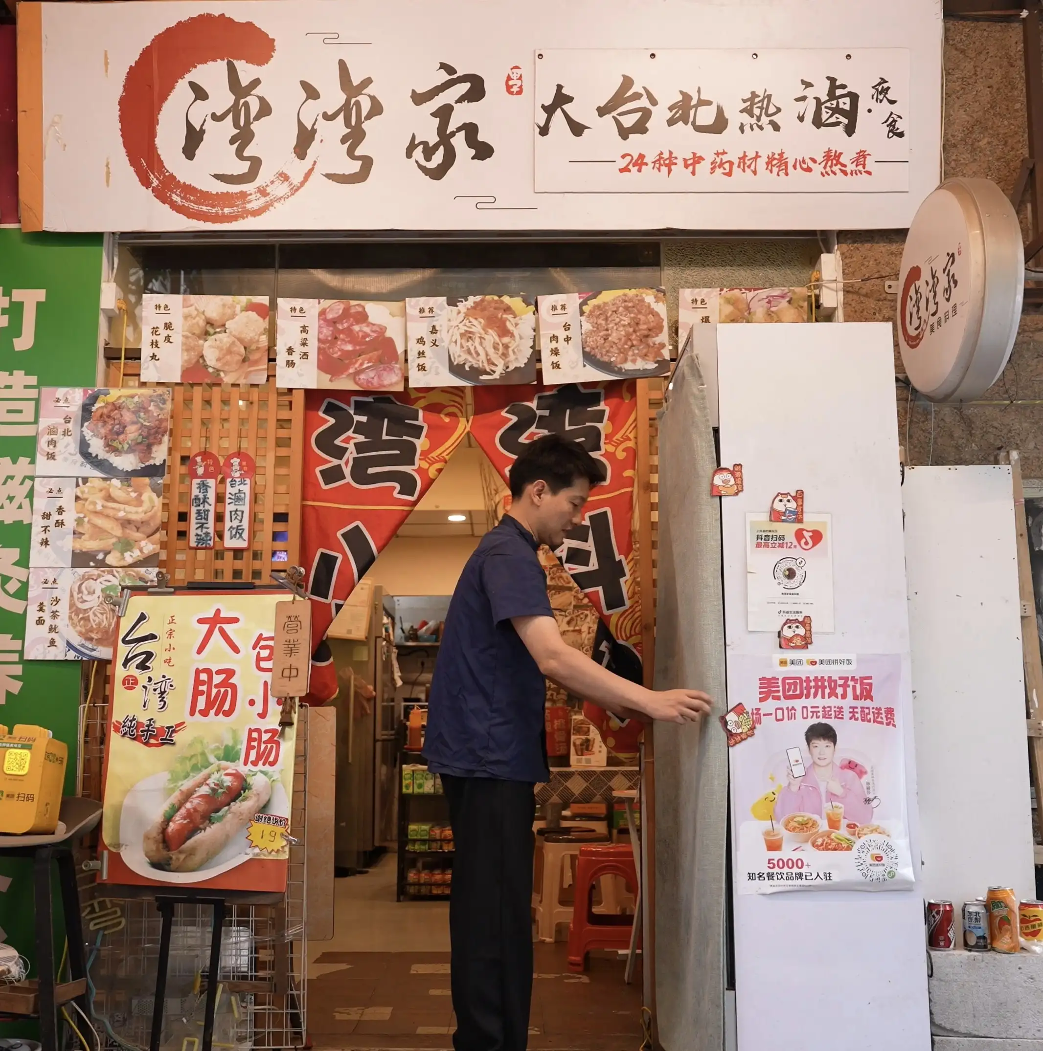 林岳廷站在自己經營的「灣灣家」小吃店門口打理店務。這間僅十平方米的小店，已成為許多在穗台灣人尋找鄉愁的據點。(記者楊婉攝)