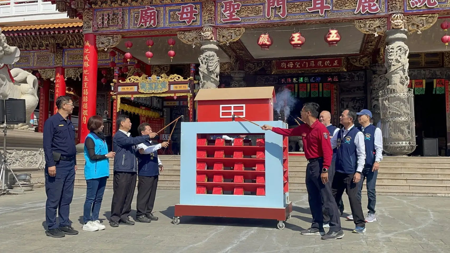 廟方代表於廟埕前共同點燃象徵儀式，預告元宵夜將有搶春牛、蜂炮與高空煙火展演。(圖/記者林怡孜攝)