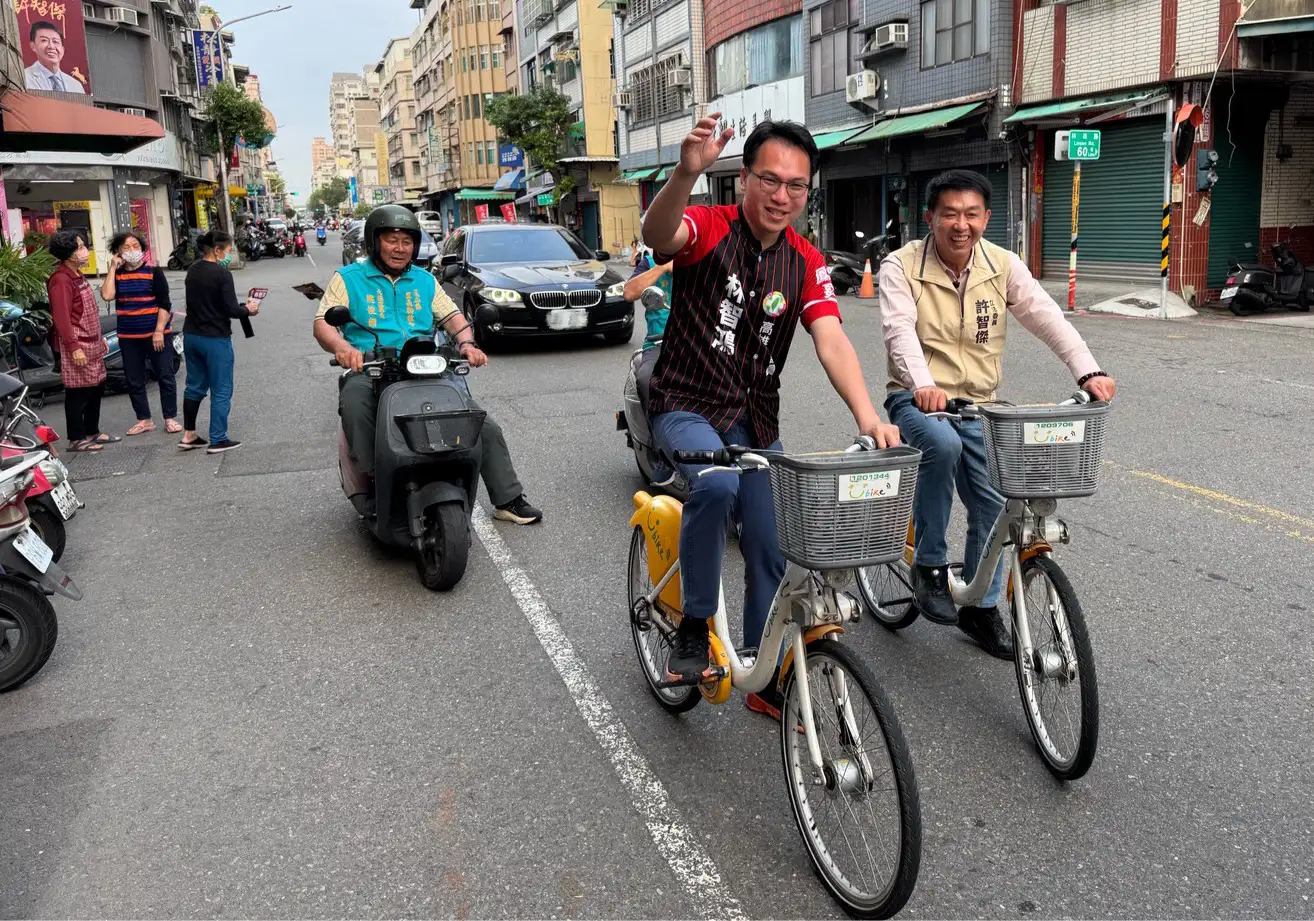 立委許智傑情義相挺市議員林智鴻，騎腳踏車陪同掃街、合體拍片，看板也將「究極合體」，展現團結氣勢。（圖/林智鴻提供）