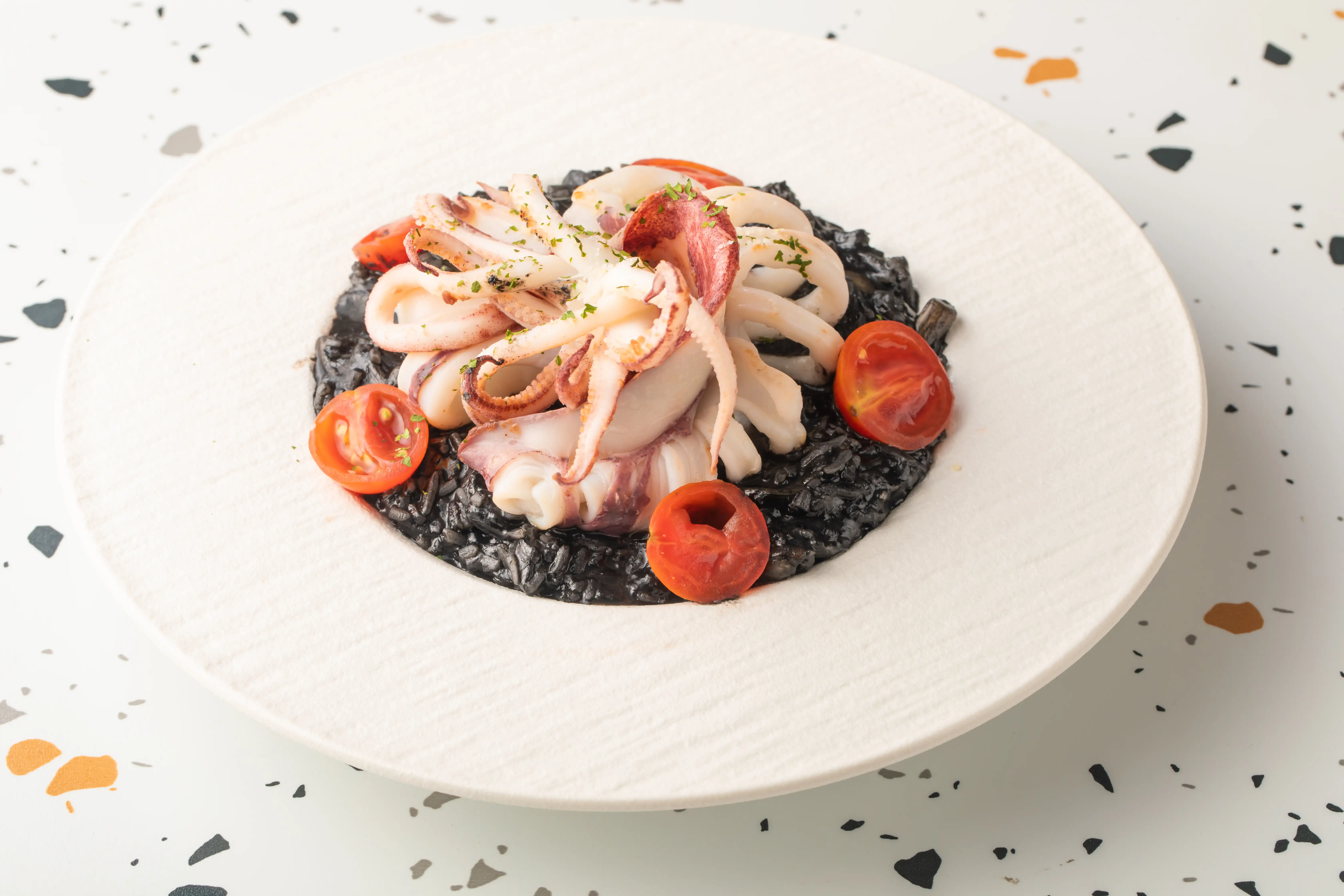 濃郁系「墨魚中卷燉飯」鋪上一整隻中卷，視覺與風味兼具。(圖/ 雪山貓咖啡提供)