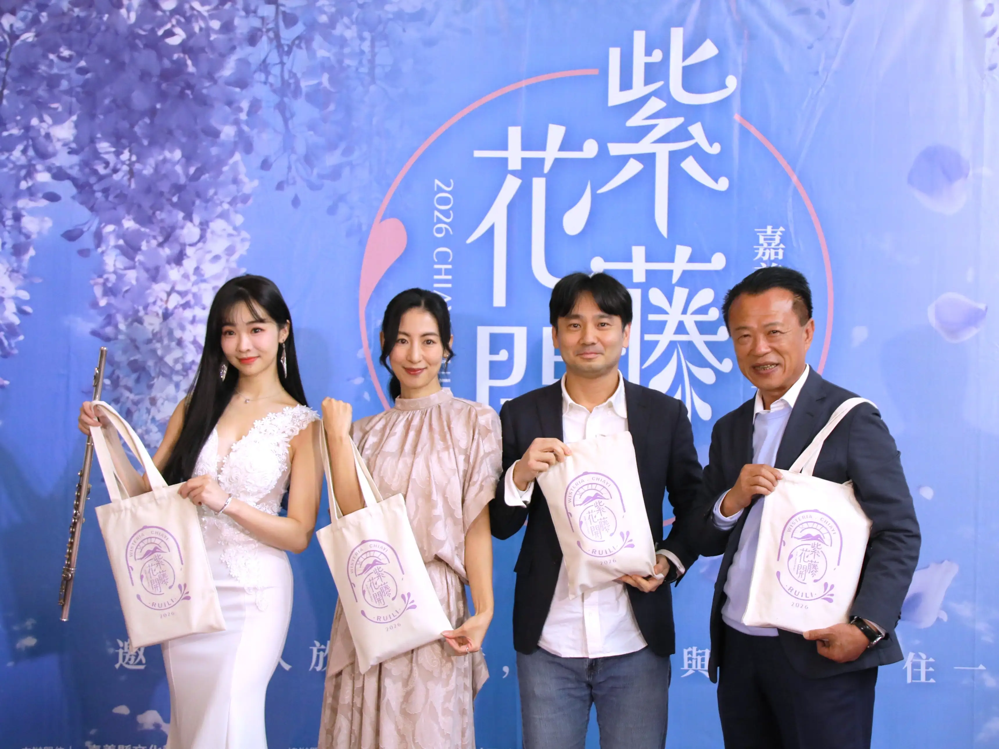嘉義縣長翁章梁（右一）與藝人大久保麻梨子（左二）等人於記者會合影，並展示紫藤花季限定紀念袋，邀請民眾春季到瑞里賞花旅遊。（圖/嘉義縣文化觀光局提供）