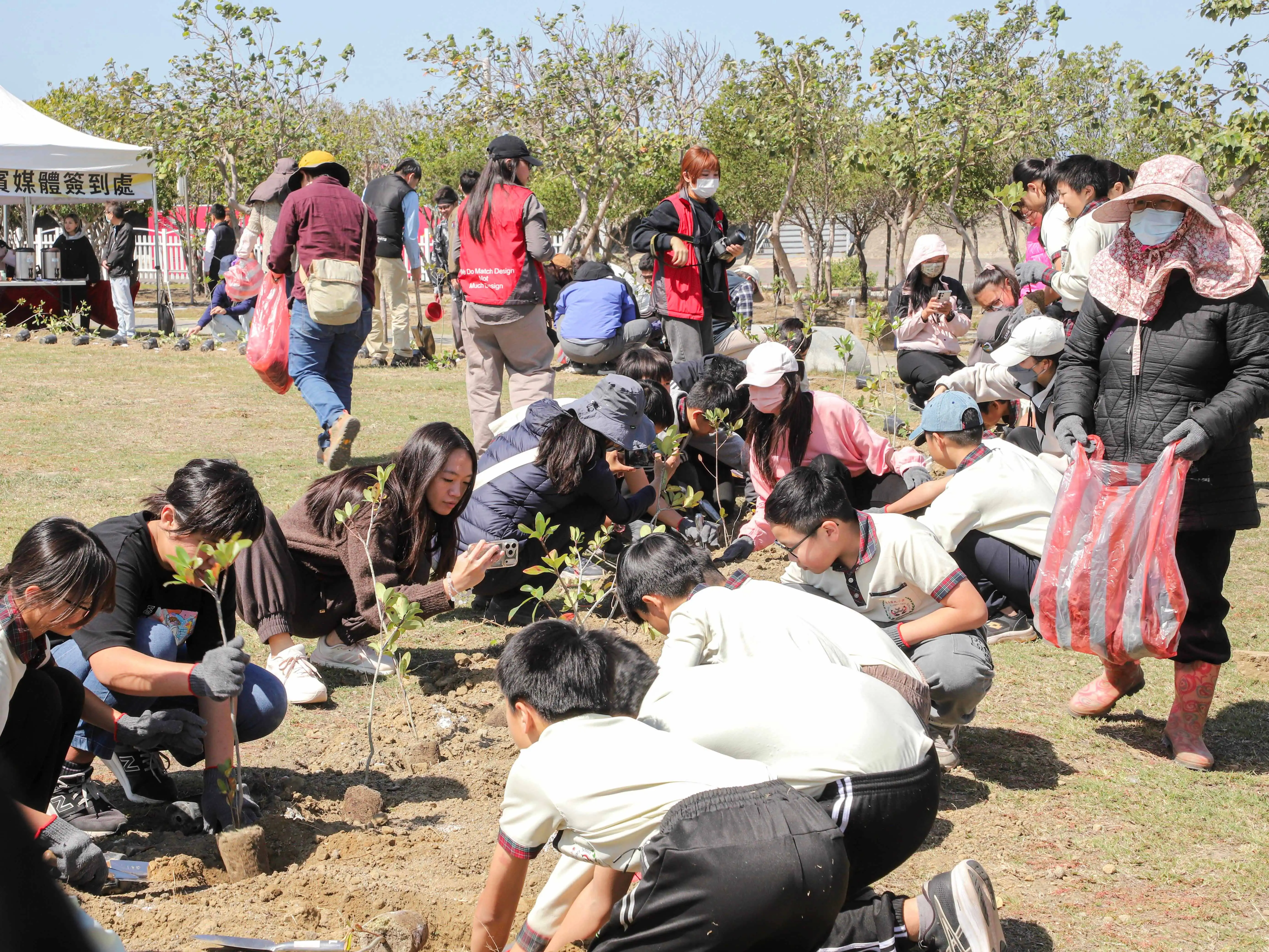 布袋國小學生及民眾在高跟鞋教堂園區參與植樹節活動，齊心種植喬灌木，為濱海景觀增添綠意並推廣環境教育。(圖/交通部觀光署提供)