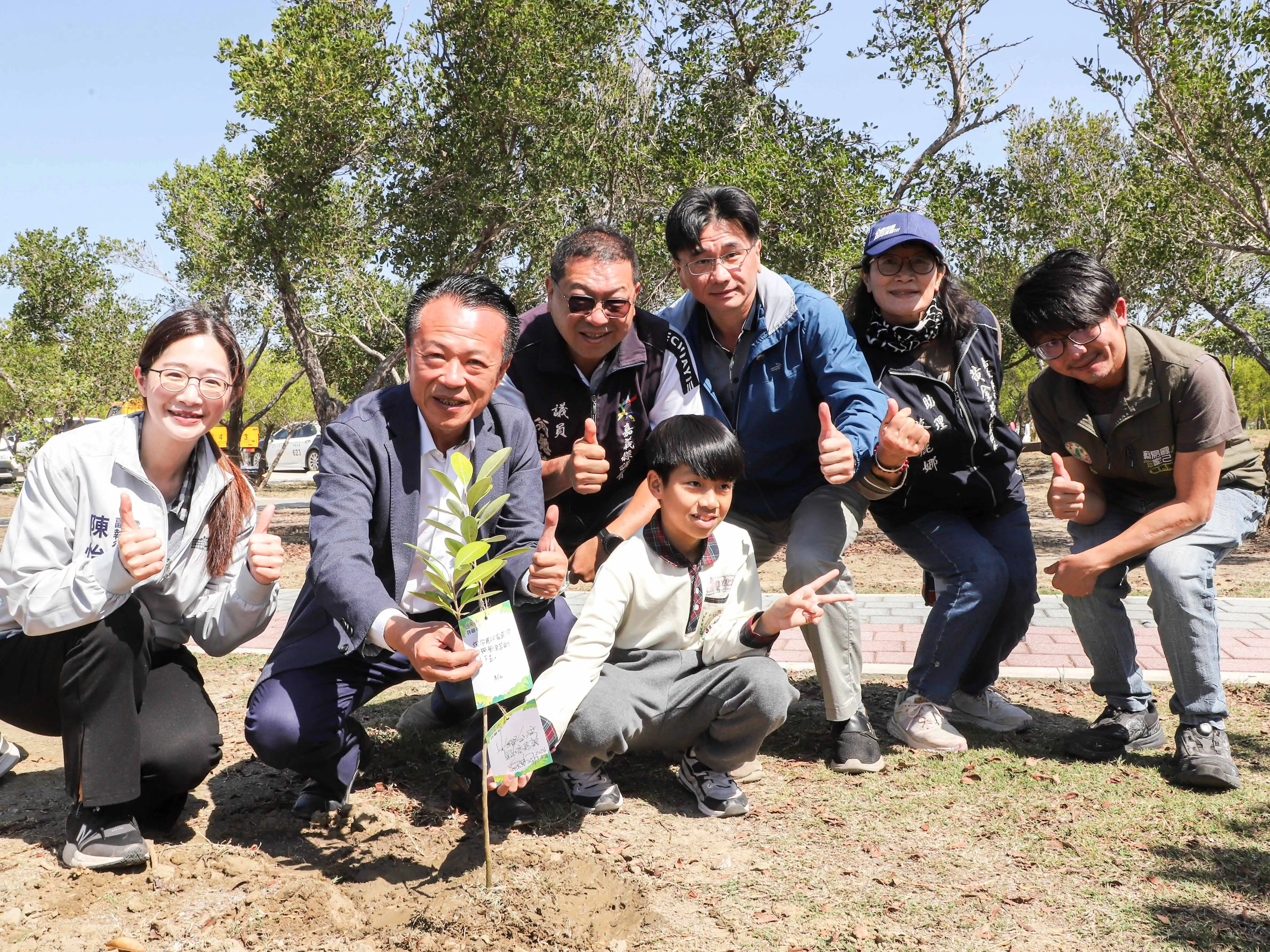 嘉義縣長翁章梁與雲嘉南濱海國家風景區管理處長徐振能及布袋國小學生共同完成植樹，並展示手寫祈福卡，為園區增添綠意與祝福。(圖/交通部觀光署提供)