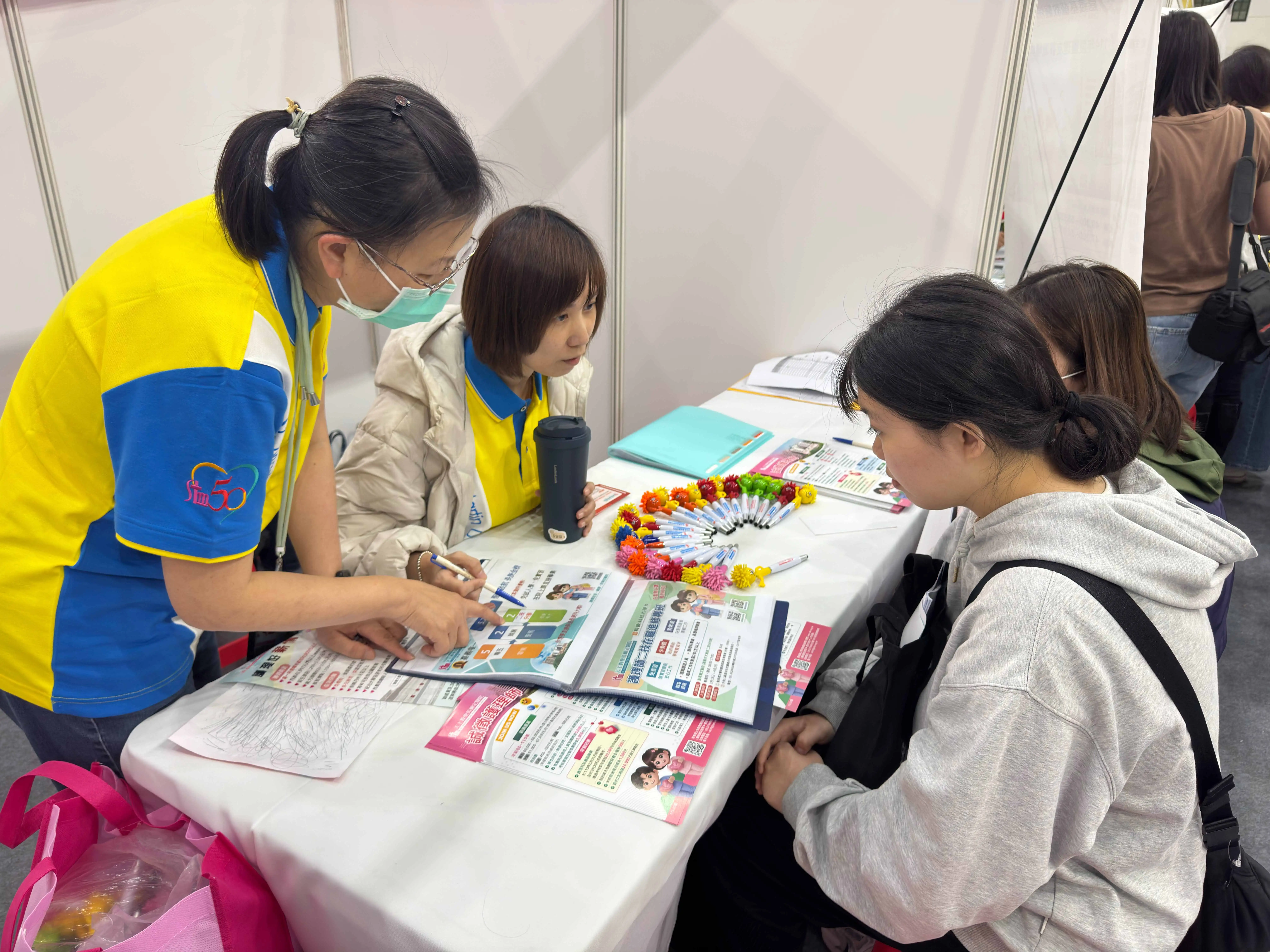 校園徵才就業博覽會現場，學生於企業攤位前與徵才人員面對面交流，了解職缺內容與發展機會，積極為畢業後就業提前布局。(記者張振興攝)