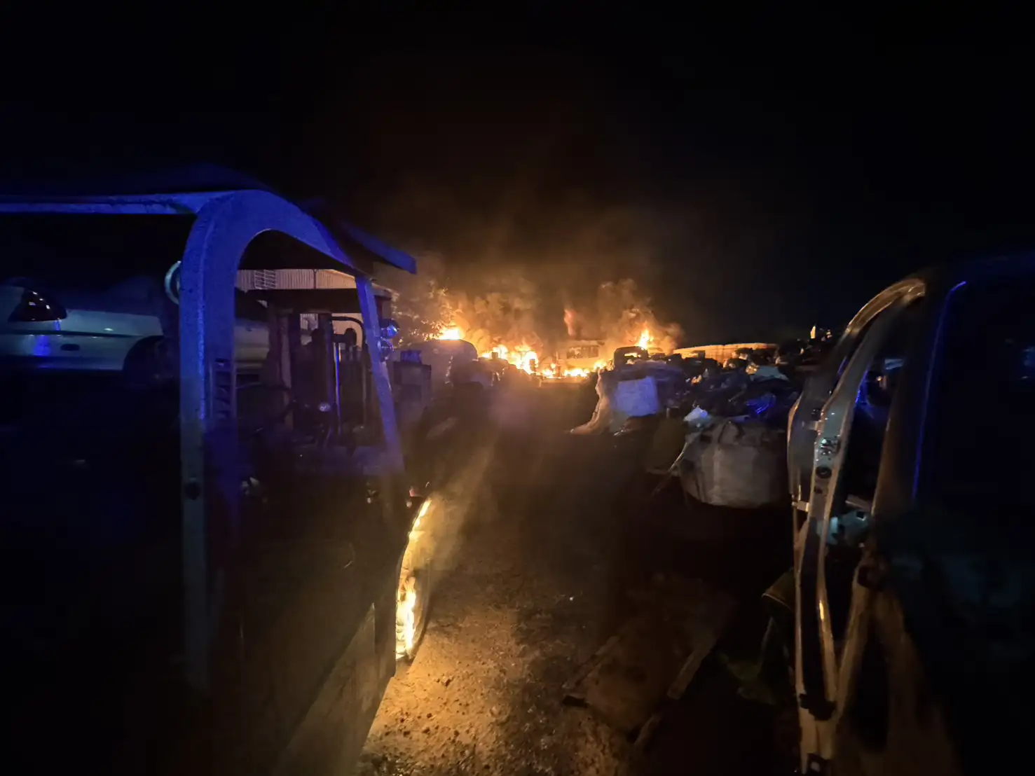 台南市仁德區一處廢五金回收工廠23日晚間發生火警，現場濃煙竄升、火勢猛烈，消防人車沿路佈署搶救，並防止火勢延燒至周邊建物。(圖/台南市消防局提供)