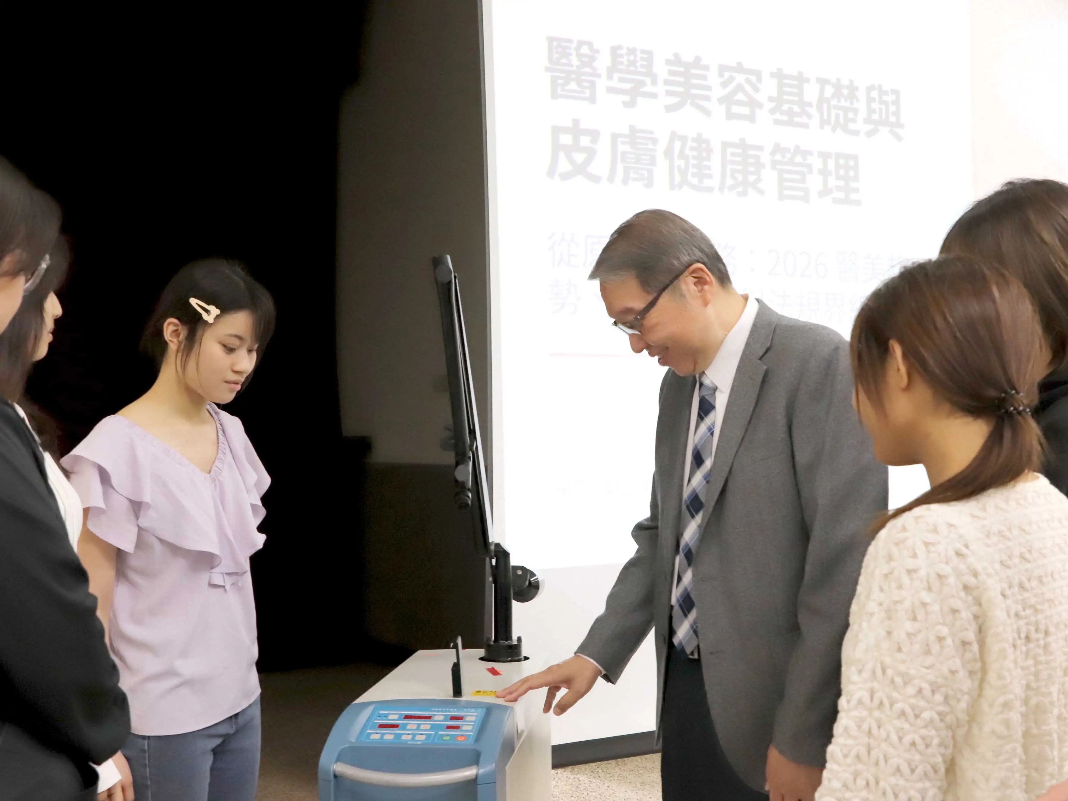 許乃仁醫師現場示範及解說雷射儀器操作，近距離指導學生。(圖/中華醫事科技大學提供)