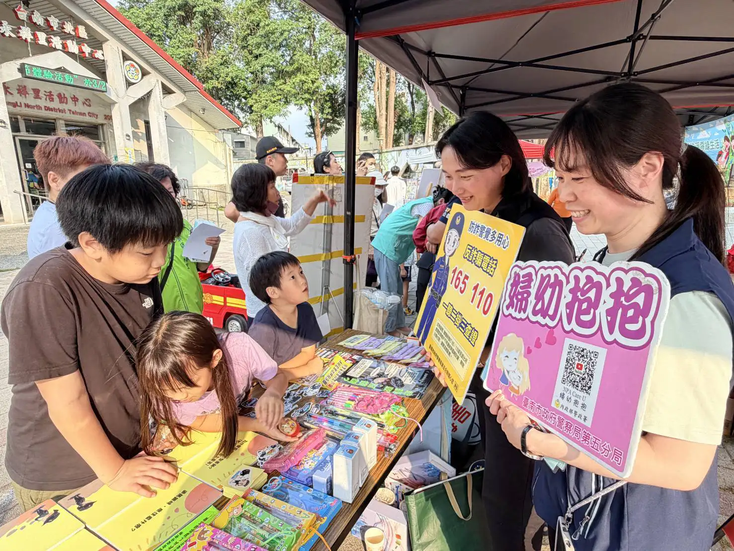 台南市警察局第五分局於社區活動設攤宣導，透過互動遊戲與宣導品發放，向親子族群推廣交通安全、反詐騙及婦幼保護觀念。（圖/第五分局提供）