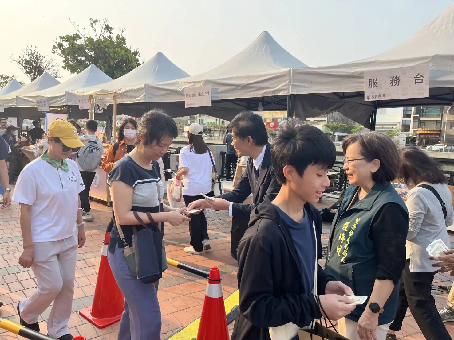 台南市副市長葉澤山於運河畔市集發放限量「即享券」，吸引民眾排隊領取。(圖/台南市政府提供)