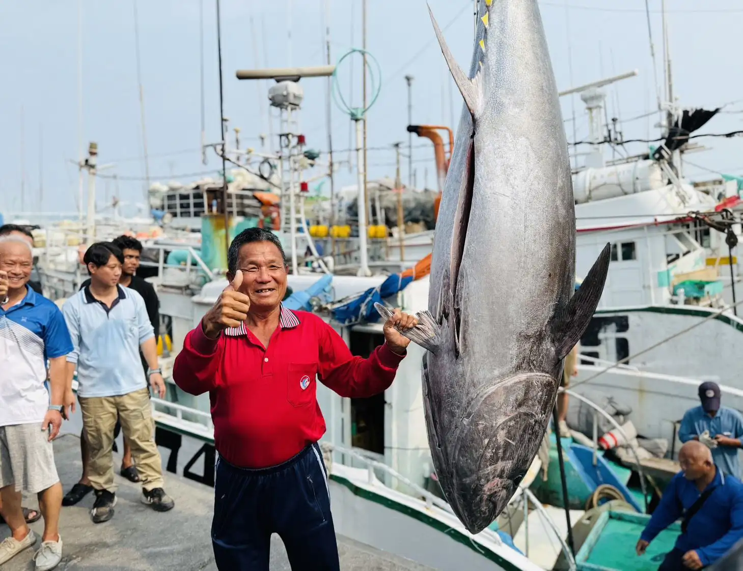 富漁慶2號船長洪福家與所捕獲黑鮪魚合影，成功奪得2026屏東第一鮪頭采。(圖/屏東縣政府提供)