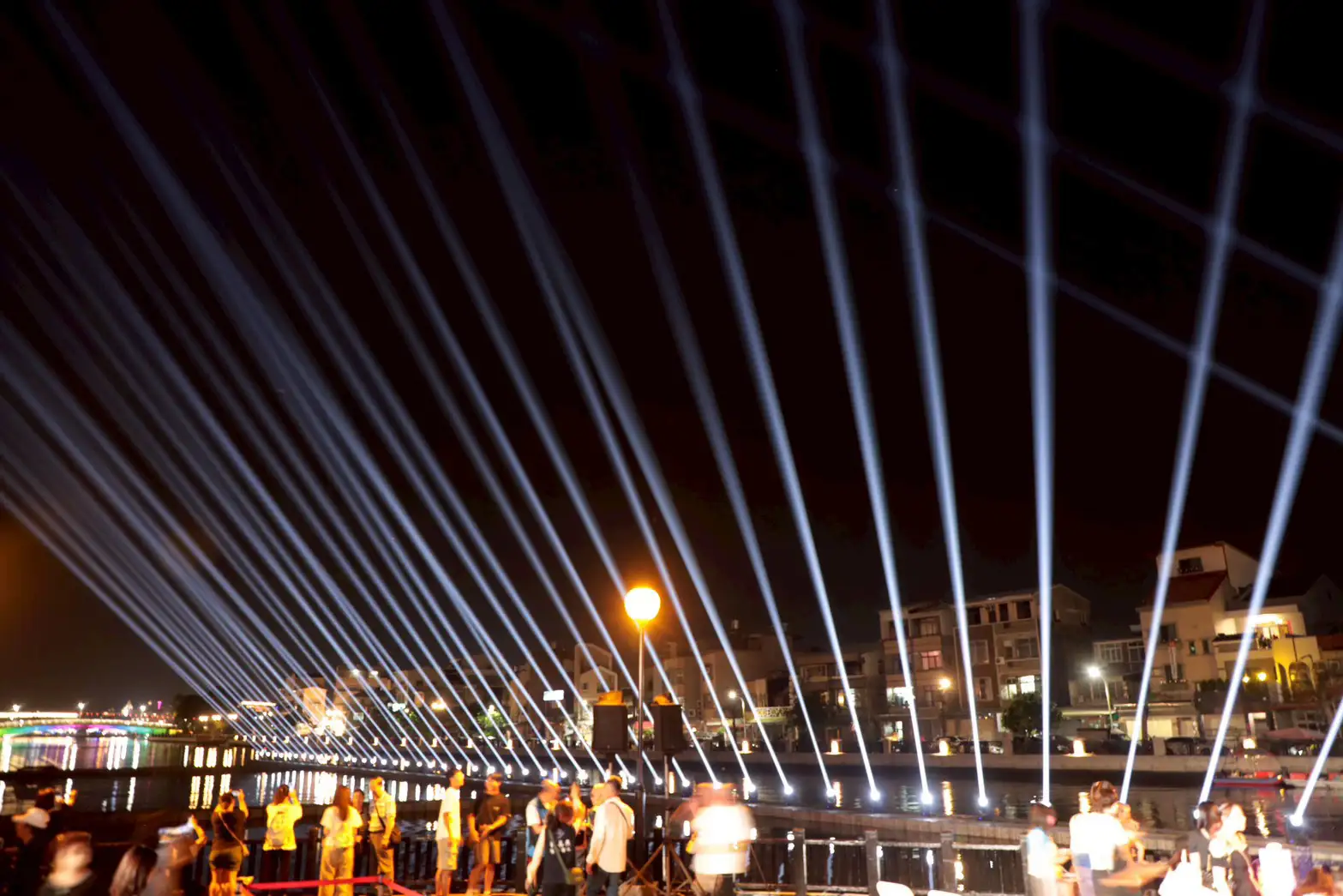 台南安平運河水岸燈光秀登場，光束隨音樂節奏律動，打造壯觀的「光之運河」，吸引民眾駐足觀賞。(圖/台南市政府提供)