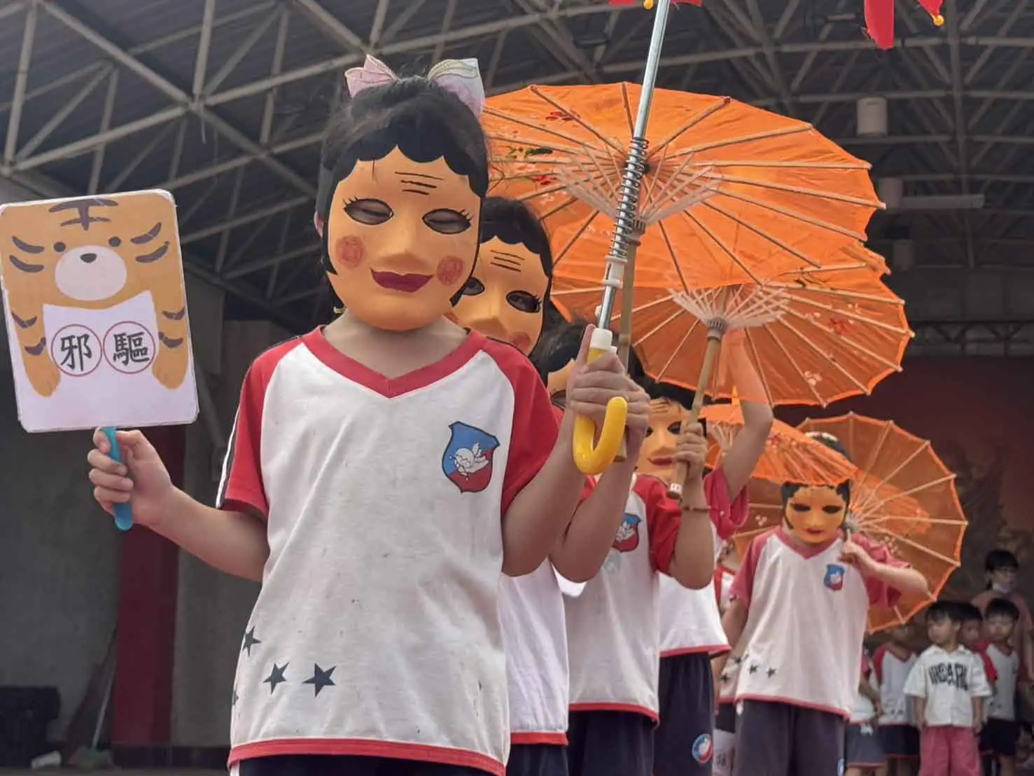 小朋友化身十二婆祖登台演出，手持道具、戴上面具，以童趣方式詮釋傳統陣頭文化。(圖/灣裡萬年殿提供)