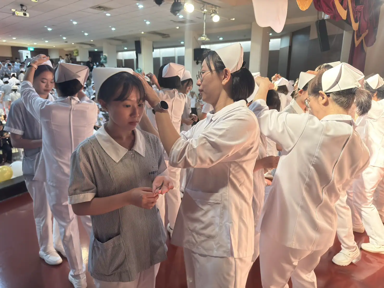 中華醫大護理系老師逐一為學生戴上象徵專業與責任的護士帽，象徵護理精神的傳承。(圖/記者張振興攝)