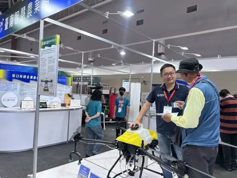台南智慧農業館展出農業專用無人機設備，現場由參展廠商向與會者介紹智慧噴灑與精準農業應用技術，展現智慧農機發展成果。(圖/台南市政府農業局提供)