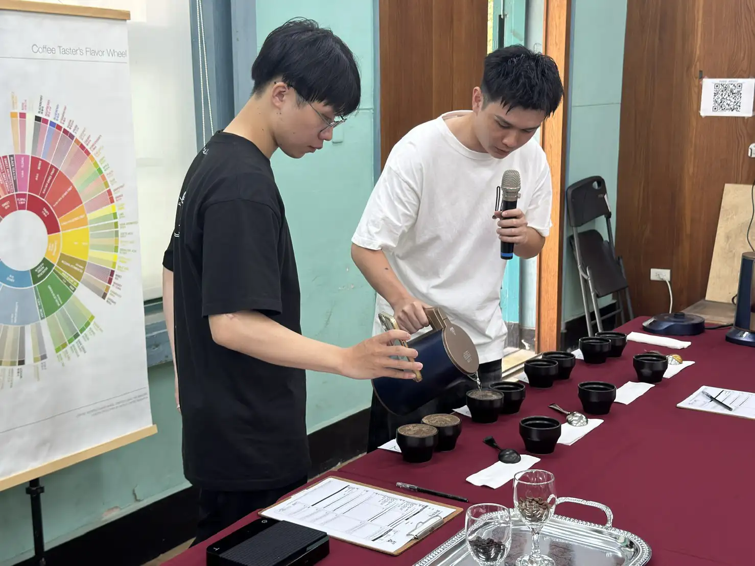 杯測師張子軒（右）與吳泓霖（左）於工作坊現場進行精品咖啡杯測示範，解析不同咖啡豆風味特色。(記者張振興攝)