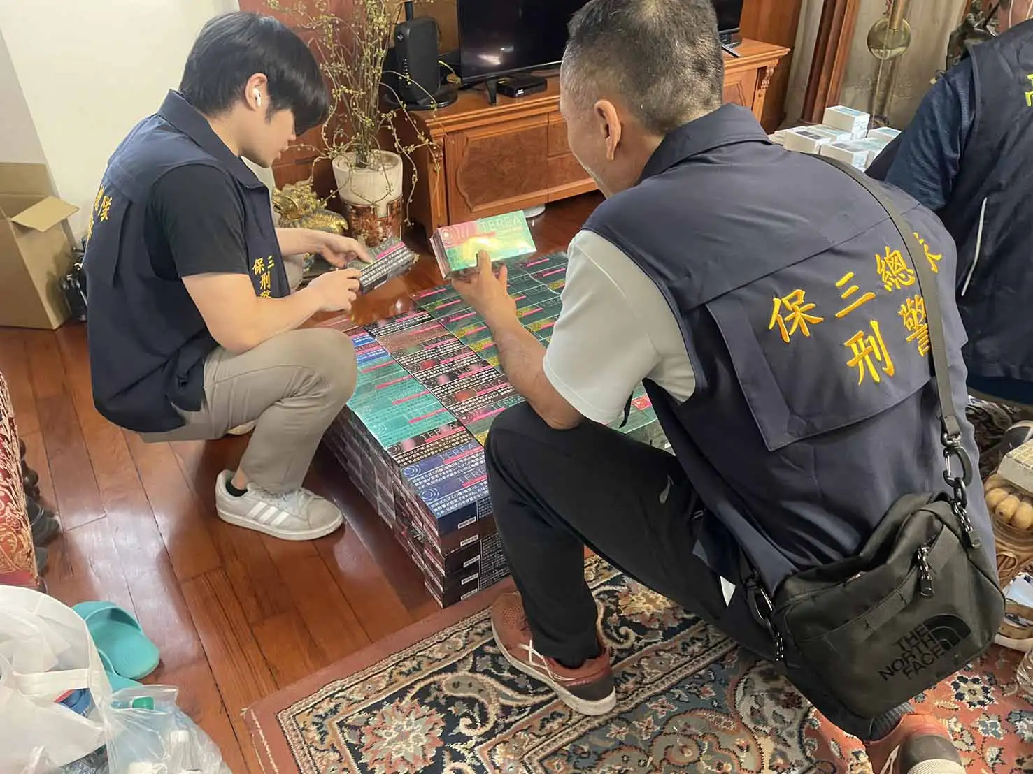 保三總隊第二大隊高雄偵查分隊會同高雄市政府財政局及衛生局，前往高雄市新興區一處私菸倉庫搜索，查扣大批非法加熱菸及相關證物。(圖/保三總隊第二大隊高雄偵查分隊提供)