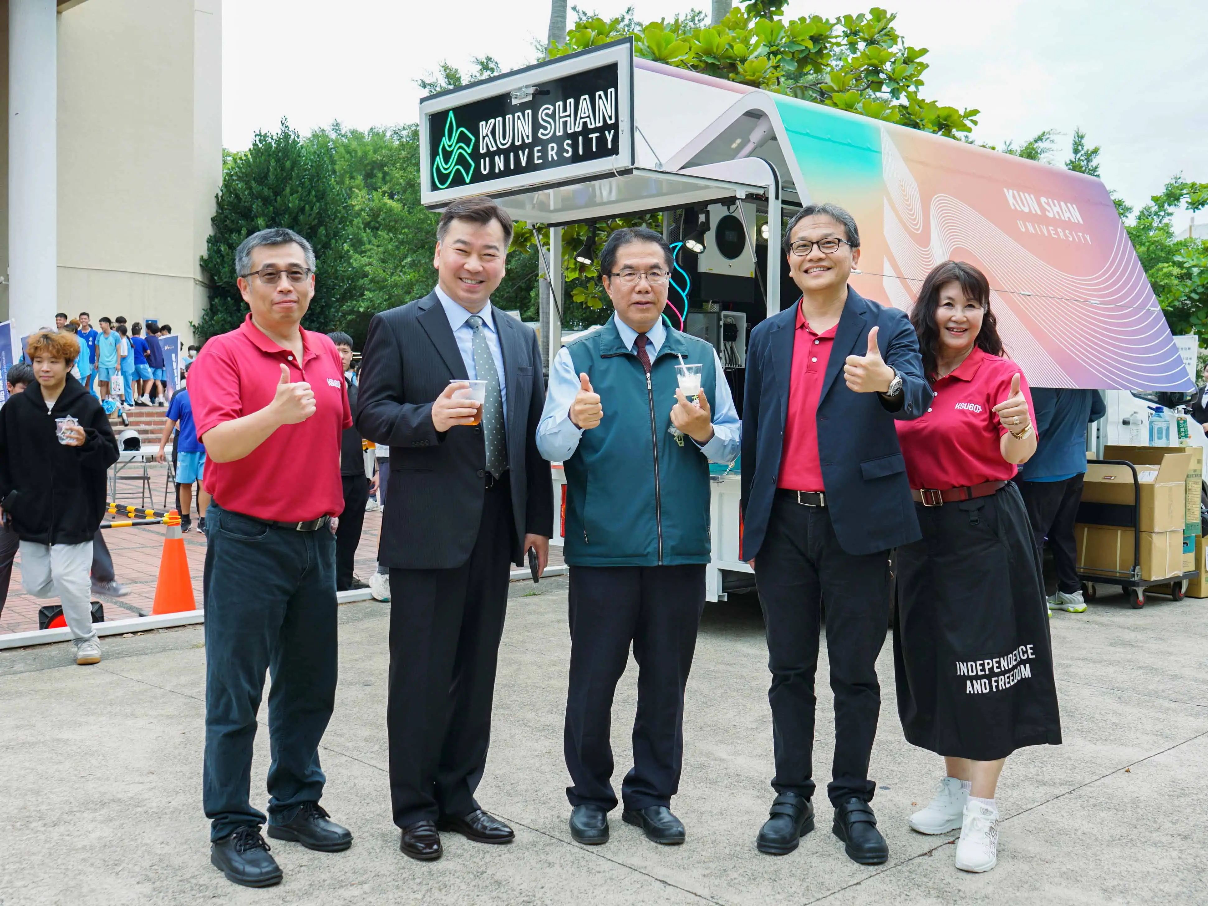 黃偉哲市長(中)參訪崑山科大「行動門市電動車改裝」，並享用該校餐飲系準備的精緻甜點。(圖/崑山科技大學提供)