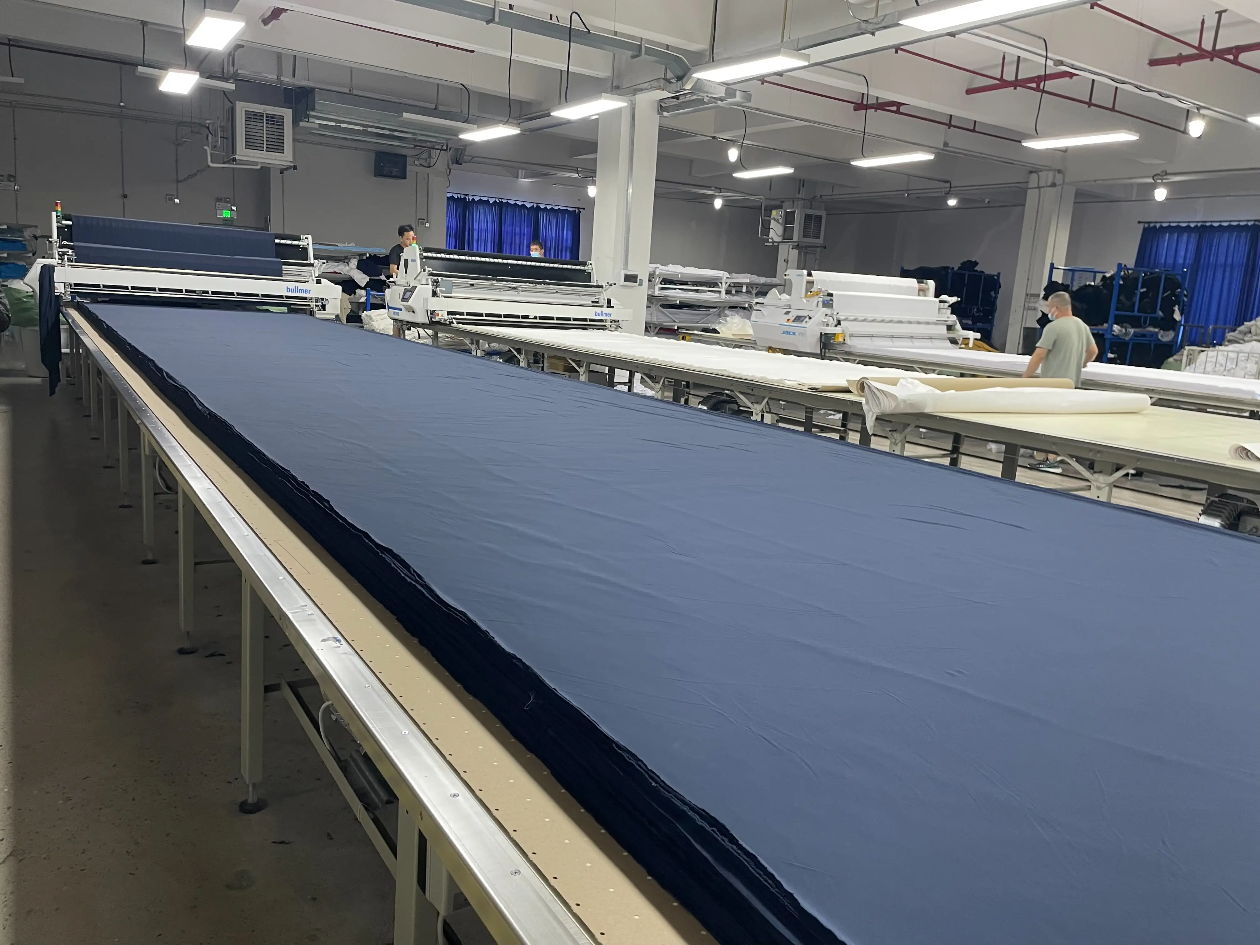 瑞蒽成衣工廠使用全自動拉布機與智慧裁床系統，透過數位化設備提升布料裁切效率與精準度。（記者林怡孜攝）