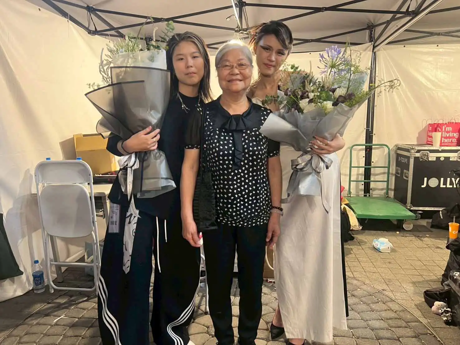 徐靜宜(左)與外祖母(中)共同製作畢製《無·域》服裝，與走秀模特兒共同合影留念。(圖/崑山科技大學提供)