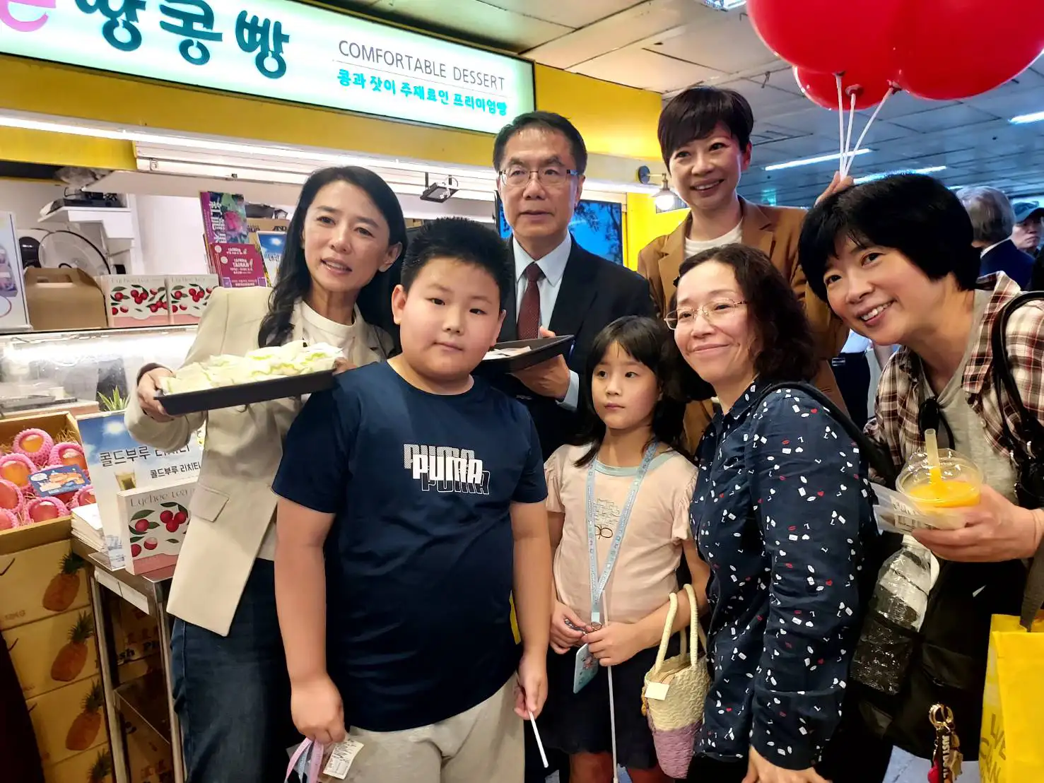 台南市長黃偉哲（中）率團於首爾地鐵商圈舉辦台南農特產品快閃展售活動，現場吸引大批韓國民眾熱情參與，不少民眾爭相與黃偉哲合影留念。(圖/台南市政府提供)