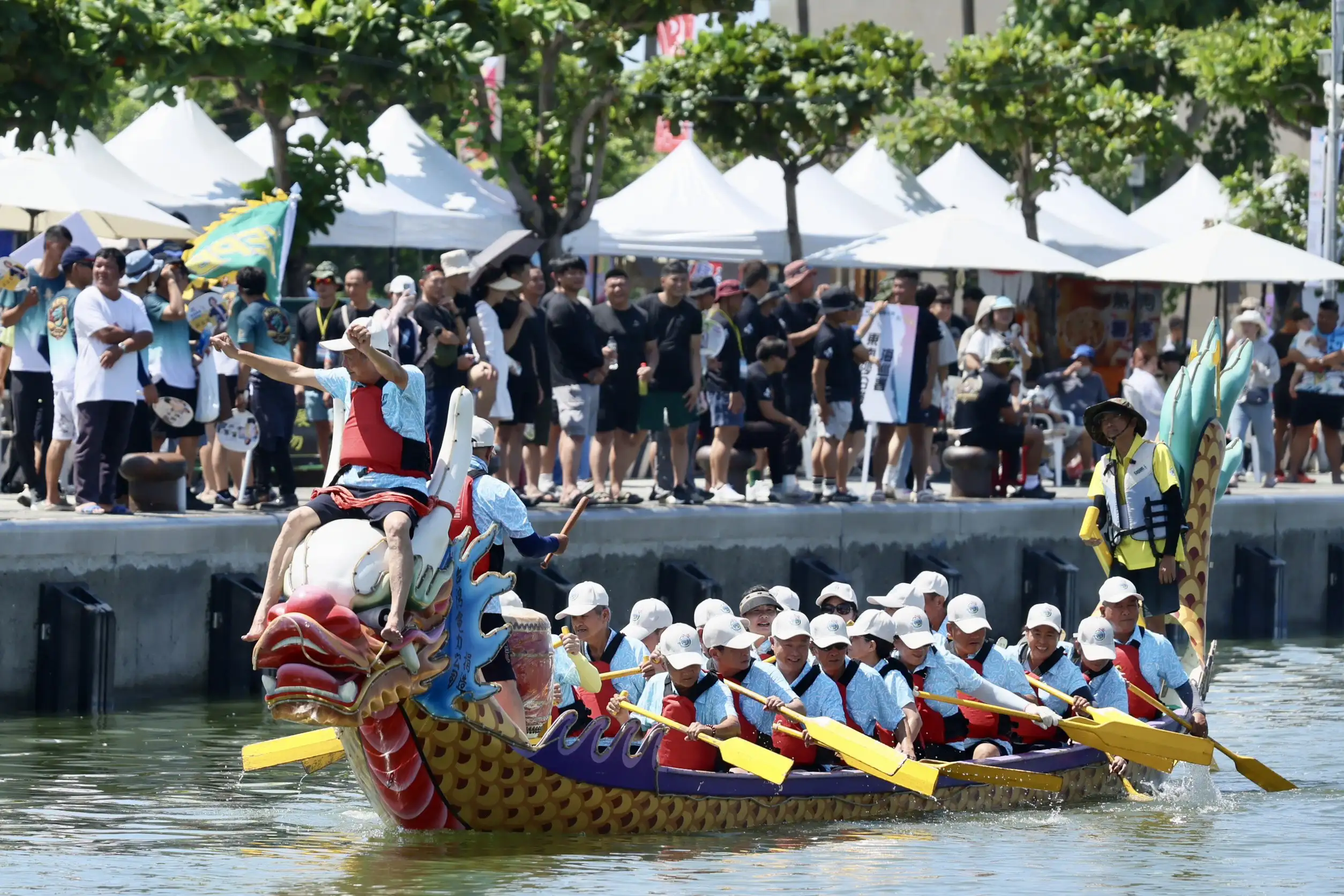 高雄市林園傳統龍舟賽在中芸漁港熱鬧登場，參賽隊伍奮力揮槳競速，展現團隊默契與拚戰精神，吸引大批民眾到場觀賽加油。（圖/高雄市政府提供）