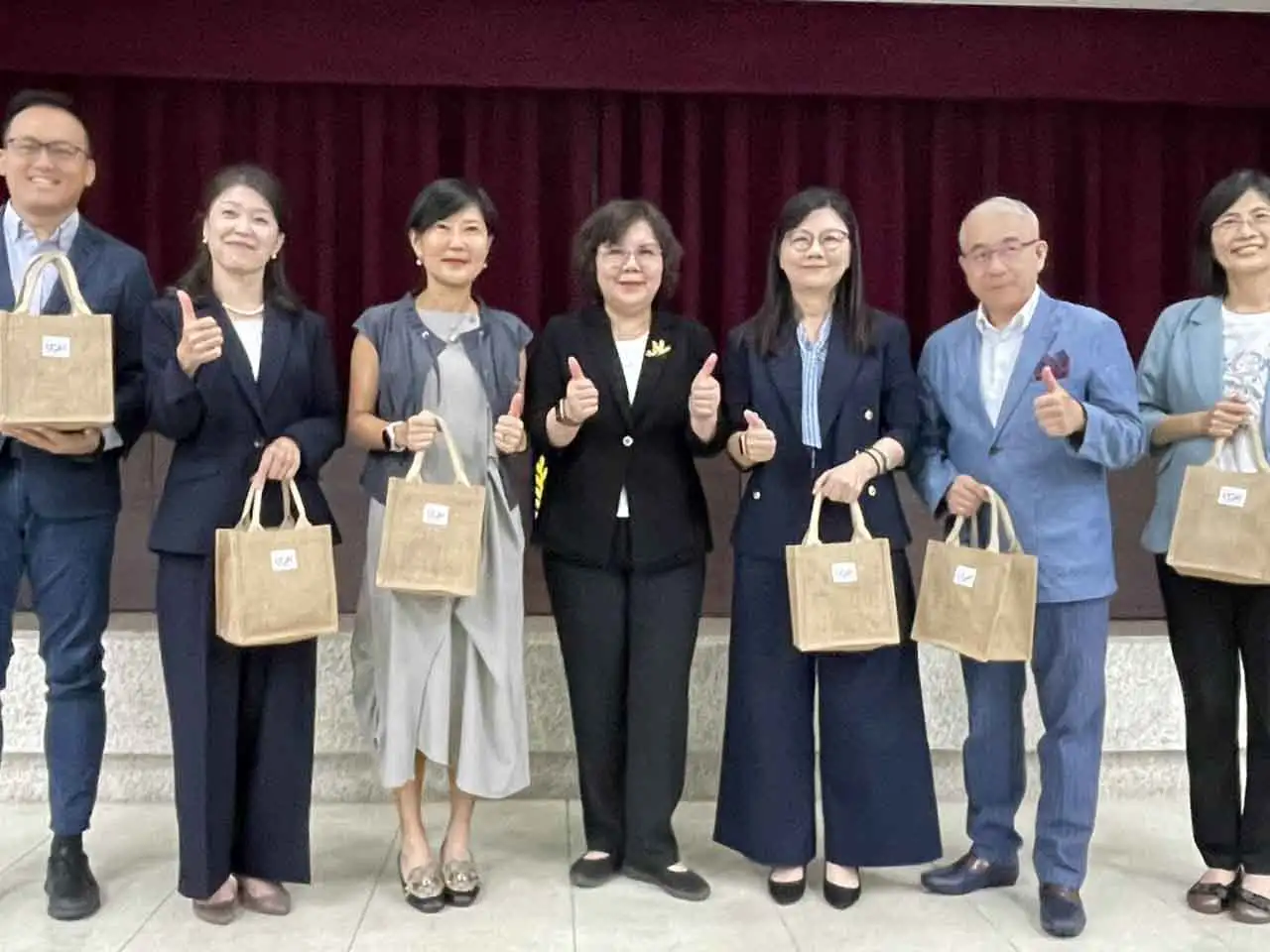 中華醫大USR計畫主持人李碧娥校長（中）以USR團隊協助東山和後壁區農特產研發的產品作為伴手禮致贈與會貴賓。(圖/中華醫大提供)
