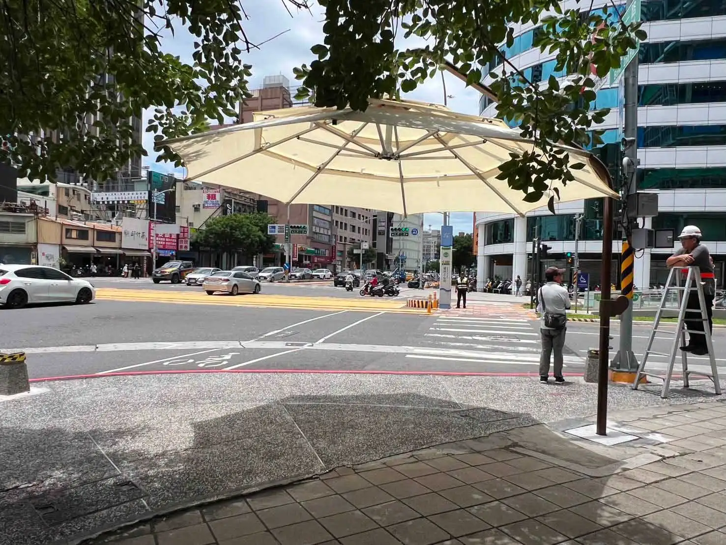 高雄市議員李雅慧表示，植樹與設置遮陽傘並非互相取代，而是相輔相成，可有效擴大人行道遮蔭範圍，提升行人通行舒適度。（圖/取自李雅慧臉書）