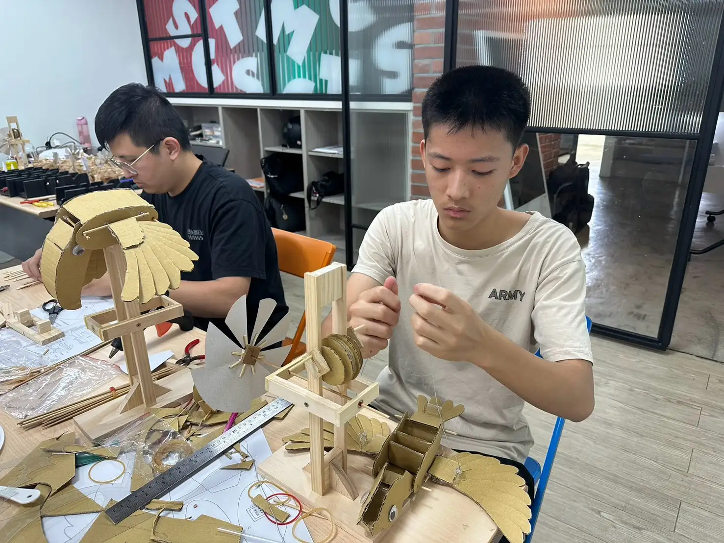 學員專注組裝風力仿生鳥作品，透過反覆測試與調整，將創意設計轉化為可運作的機械作品。(圖/南方實作基地提供)