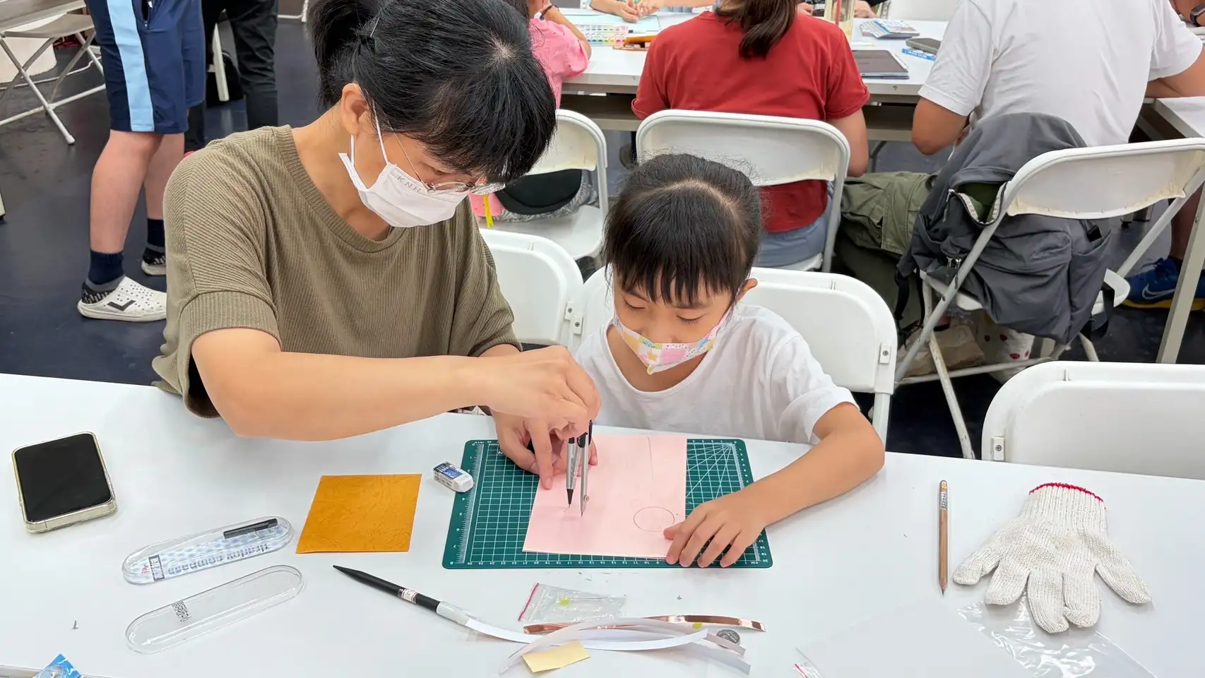 親子共同完成光控卡片，當作品成功發光時，現場充滿驚喜與歡呼，讓科技學習增添親子互動的溫度。（高雄市立圖書館河堤分館提供）