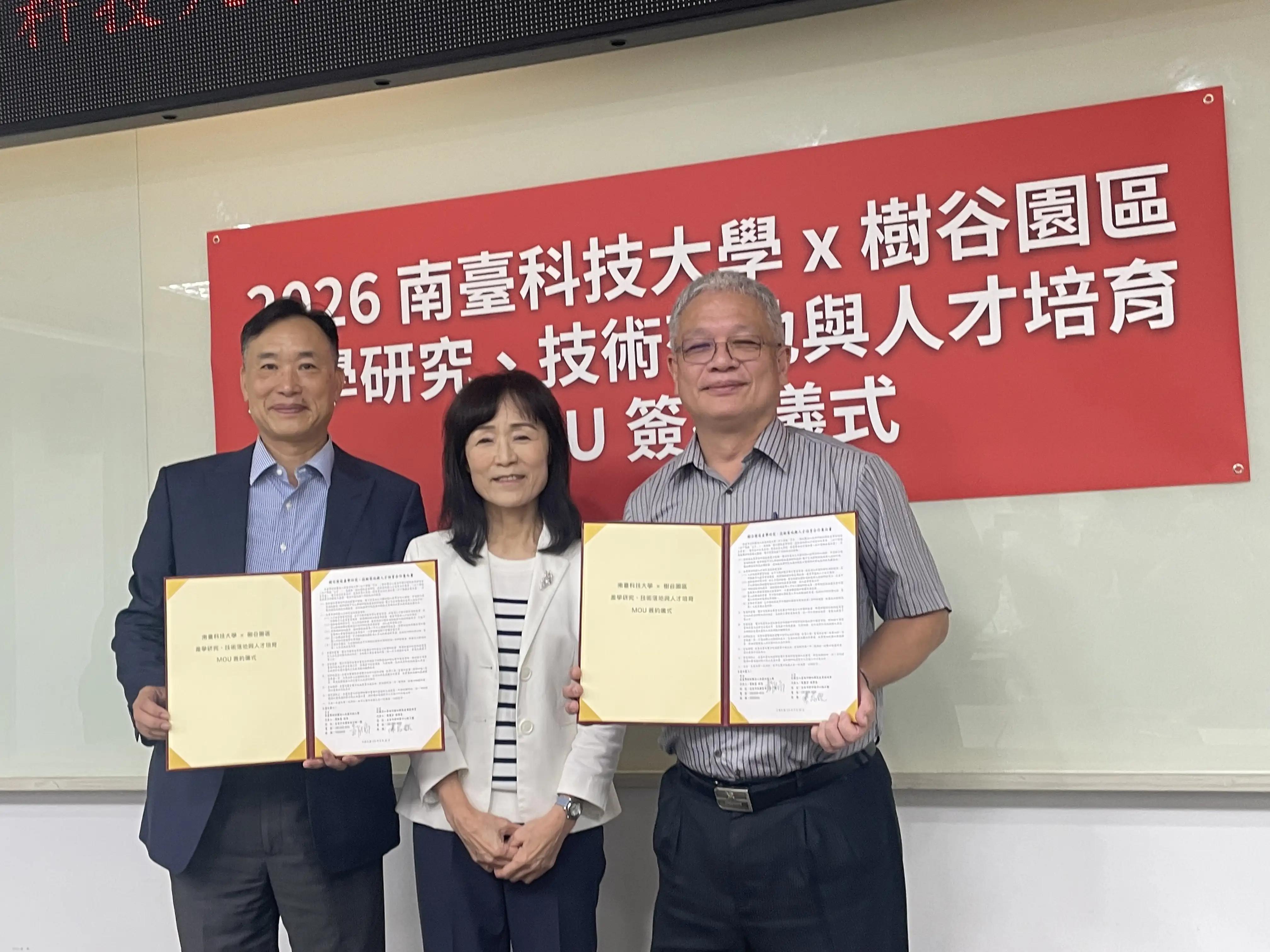 南臺科大與樹谷產業園區簽署產學合作MOU，由校長黃能富(左)、華美光學科技董事長陳志銘(右)代表簽約，南臺科大董事長蘇慧貞見證(中)。(圖/記者林怡孜攝)