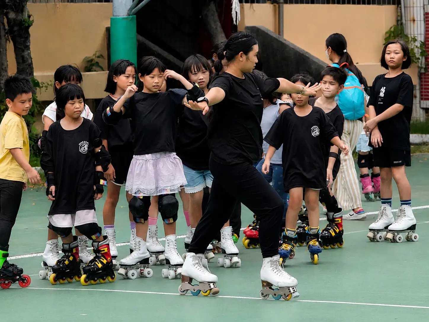 教練帶領小學員進行滑行及基本動作練習，孩子們在遊戲與闖關中體驗花式溜冰樂趣。（圖／記者范繼如攝）