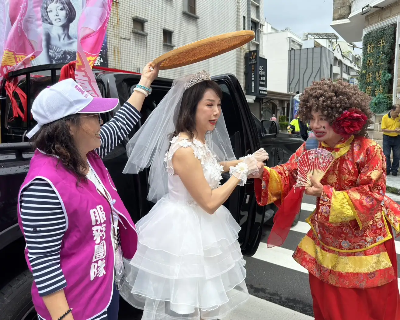 台南市北區、中西區市議員參選人童小芸身披白紗，在傳統媒婆牽引下前往台南市選舉委員會完成參選登記，以「嫁給台南」為主題，象徵對地方服務的承諾與責任。（記者張振興攝）
