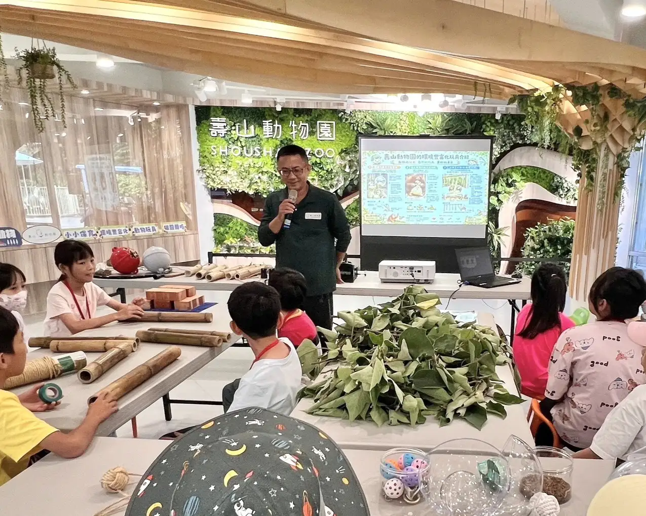 園方人員向營隊小朋友解說「環境豐富化」覓食玩具製作方式，讓孩子透過親手製作了解動物習性及保育工作。（高雄市觀光局提供）